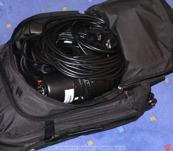Trolley Reisekoffer ARAL\n\nFoto von Jrg Langer\n\nKommentar des Nutzers:\n\nDieser Trolley aus einer Punkte Aktion der ARAL und passend fr die kleine Studioblitzausstattung.\n\nWir haben hier reingepackt:\n\nHauptfach:\nStudioblitzleuchte 420Ws\nStudioblitzleuchte 260Ws\n(in einem Handtuch gegen Ste und Reibung etwas gesichert)\noben drber "kneulen" wir Schwarze und weie Stoffe die man im STudiobetrieb immer wieder mal brauchen kann.\n\nIm aufgesetzen Rucksack /der Fronttasche auf dem Trolley sind:\n\nStudioblitzleuchte klein 100Ws miit Spotvorsatz, 15 Meter Stromverlngerung, Steckdoesenleiste, Stromkabel fr die 3 Studioblitze\n\nIn der Fronttasche der Fronttasche ;-) sind dann:\n\n2 X-Sync Kabel 5m fr die 3 Blitze (der kleine und die groen nutzen unterschiedliche und Ersatz soll ja auch dabei sein ;-)\n\nHinten neben dem Trolleygestell sind dann zwei kleine Reflektorschirme verstaut. Die Stative und die Softboxen werden in Ihren eigenen Taschen transportiert und liegen gesondert im Kofferraum.