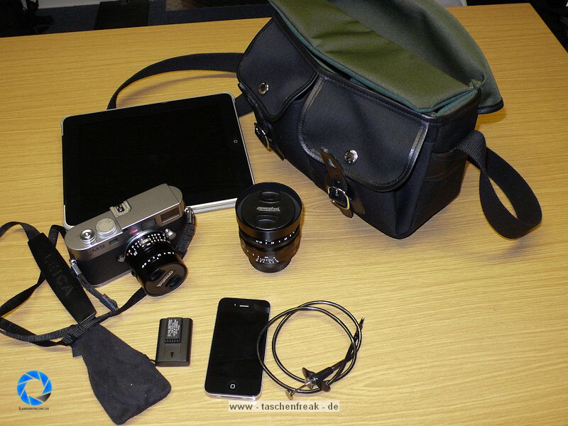 BILLINGHAM HADLEY SMALL\n\nFoto und Text von Jörg Langer - www.taschenfreak.de\n\nKommentar:\n\nDie kleinste Billingham aus der bekannten Hadley Serie. Typisch für Billingham, der edle aber sehr robuste Stoff, die unauffällige "Bauform", die Lederbeschläge für den Verschluss und der grüne "Innenraum" der sehr weich und schützend für die edlen Teile darin ist.\n\nDie "Small Hadley" ist ideal für eine kleine DSLR wie D40 oder D90 mit einem Kit oder Zoom bis max 18-200 VR oder ideal für eine Systemkamera mit angesetzten Objektiv und einem weiteren Objektiv. Hinter dem Fotofach ist ein weiches flaches Fach zu finden welchen wirklich perfekt zugeschnitten für das iPad ist und die beiden Fronttaschen nehmen gut Handy, Ersatzakku, Camera Connection Kit für das iPad oder auch Geldbörse auf. \n\nDie Tasche ist sehe edel verarbeitet, dennoch praktisch und bequem zu nutzen. Der Gurt st fest und nicht abnehmbar und leider recht rutschig auf der Jacke. Dagegen hilft das optionale Schulterpolster für den Gurt (das ich leider nicht mitbestellt habe....).\n\nAlso wer eine kleine Tasche für seine kleinen Begleiter sucht wird mit der Hadley Small sicher sehr glücklich werden!