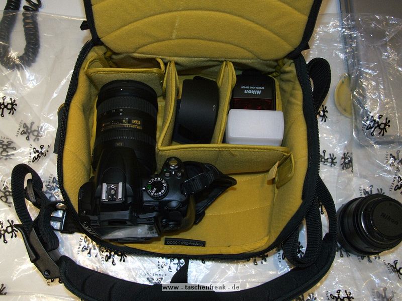 CRUMPLER GIGOLO 5500\n\nFoto und Kommentar von Frank Menzel - VIELEN DANK!\n\nKommentar des Nutzers:\n\nWie so oft bei Crumpler, muss man diese Taschen immer grer kaufen als eigentlich ntig, da der Innenraum trotz der stattlichen Aussenabmessungen eher klein ausfllt. Die 5500er macht da keine Ausnahme. Ins Hauptfach passt gerade mal eine Nikon D5000 mit Handschlaufe und angesetztem 18-200 VR, die dazugehrige Gegenlichtblende sowie ein SB-600 Blitz (angewinkelt) hinein. Mehr nicht, abgesehen von wirklichem Kleinkram wie z.B. einem Zweitakku oder zustzlichen Speicherkarten. Das originale Ladegert und eine kleine Festbrennweite wie das 35mm, f1,8 mssen zu Hause bleiben.... fr eine Panasonic GH-1 mit Zubehr wahrscheinlich genau die richtige Tasche aber eben nicht fr eine kleine DSLR mit Zoomobjektiv und Blitz. \n\nAnsonsten hat die Tasche eine tolle Optik und macht einen robusten Eindruck, die Reiverschlsse sind massiv und gleiten hervorragend. Das Konzept mit dem doppelten Deckel ist an sich gut durchdacht. Die Tasche erinnert mich an einen Schildkrtenpanzer und wirkt auch so stabil. \n\nEinzig die Innenteiler zeigen sich etwas unflexibel, da nur ein groer Innenteiler und zwei ganz Kleine beiliegen. Der groe Innenteiler ist ist nicht teilbar und so geformt, dass sich im Prinzip nur eine einzige Aufteilungsmglichkeit mit 3 Kammern ergibt und sich die zwei kleineren Innenteiler eigentlich nur zum Unterteilen der ohnehin schon zu kleinen Kammern verwenden lassen. Im Prinzip knnte der groe Innenteiler auch gleich fest vernht sein, da man ihn nicht varieren kann. Bei dem stattlichen Preis von rund 100,-- Euro fr mich unzureichend. \n\nIch habe die Tasche wegen des kleinen Innenraums und dem unflexiblen Innenteilers nicht behalten.