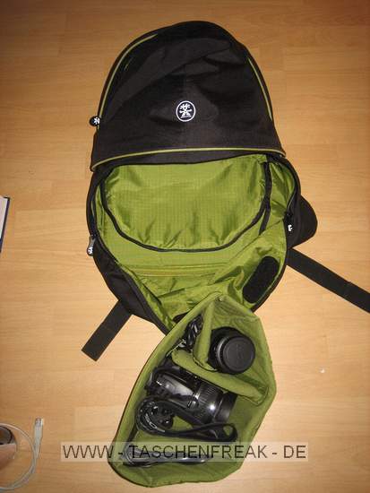 CRUMPLER - THE ROYAL COURT\n\nFoto von Andre Remy - VIELEN DANK FR DEIN MAIL!\n\nKommentar des Nutzers:\n\nHerstellerlink:\n\nhttp://www.crumpler.de/?product=Royal_Court_L&colour=Deep_Black_/_Lt._Army_G\nreen&page=details&product_id=RC-003\n\n\nEigene Meinung:\n\n'The Royal Court' ist fr mich als Einsteiger ein guter Kompromiss aus Foto-\nund Alltagsrucksack, da er von Auen recht unauffllig ist und nicht sofort\nmit einem Fotorucksack in Verbindung gebracht wird.\nWie man auf den Bildern erkennt, ist der Rucksacks zweigeteilt und\nermglicht so den getrennten Zugriff auf die Fotoausrstung. Die Polsterung\ndes Fotofachs kann man einzeln, aber auch vollstndig, entfernen und die\nTrennung zwischen Hauptfach und Fotofach aufheben, so dass man ein groes\nStaufach hat. Sehr praktisch und unauffllig ist auch das Laptopfach. Mein\n13,3" MacBook hat dort bequem Platz, bei greren Notebooks wrde ich vorher\nallerdings die Mae auf der Crumpler-Website vergleichen.\nStaufcher fr Kleinigkeiten wie Stifte, Zettel, Akkus, Speicherkarten, usw.\ngibt es fr mich mehr als ausreichend. Sehr praktisch sind auch die kleinen\nSeitenfcher auf beiden Seiten, die sich whrend des Tragens bequem\nerreichen lassen. Mein Handy aber auch ein PDA oder ein paar Schokoriegel\nhtten dort zum Beispiel Platz.\n\nDie auf dem bersichtsfoto abgebildeten Dinge schleppe ich natrlich nicht\nalle mit mir rum, sondern waren einfach nur gerade verfgbar um den Rucksack\nzu fllen. Statt dem dicken Wrterbuch und der Weinflasche wrde im\nHauptfach natrlich auch eine dickere Regenjacke Platz finden.\n\nDer Tragekomfort ist durch die dicken Rckenpolster und breiten\nSchultergurte recht angenehm, der Brustgurt entlastet den Rcken noch\nzustzlich ein wenig, allerdings nicht so stark wie ein Beckengurt.\n\nInsgesamt ist der Rucksack sehr gut verarbeitet, Foto und Laptopfach gut\ngepolstert und die Reiverschlsse sind sehr robust. Fr mein empfinden\netwas schwergngig, aber vielleicht gibt sich das mit der Zeit.