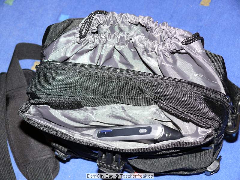 Drr City Bag\n\nFoto von Jrg Langer\n\nKommentar des Nutzers:\n\nEine kleine Fototasche die nicht nach Fototasche aussieht und genau damit wird sie m.E. Ihrem Namen "City Bag" sehr gerecht.\n\nEs passen in dieses kleine Packwunder gut rein:\n\n- eine DSLR mit einem relativ groen Standardzoom wie einem 28-300er oder einem 18-200er oder hnlichen Formfaktoren. Ein Canon 24-70 2,8L ist etwa 1 cm zu lang. In unserem "Packbeispiel hier haben wir ein 12-24 mit 82er Filterdurchmesser verwendet was deutlich grer ist als eins der genannten Reisezooms.\n\n- dazu eine 50er Festbrennweite und einen groen Systemblitz und Akkus dazu.\n\n- In die vielen kleinen und greren Reisverschluss und Kletttaschen passen dann gut, Geldbrse, PDA, Handy und CF Cards sowie anderer Kleinkram rein.\n\nDier Tasche lsst sich sehr angenehm als Schulter- oder auch Torsotasche tragen.\n\nDer Preis ist mit 35 Euro vergleichsweise gnstig und dadurch ist die Drr City Bag auch gut als "Zweittasche" haltbar.\n\nDie Verarbeitung ist sehr hochwertig und sehr robust.\n\nDie Innentasche wird mit einem Kordelverschluss verzogen/verschlossen und dadurch ist die Cam auch relativ "Wasserfest" untergebracht.\n\nLeider passt auch das Equipment der Frau wie auf 2 Bildern zu sehen hervorragend hier rein, was den Innerfamiliren Konflikt "wer nutzt welche Tasche" nicht einfacher macht ;-)\n\nTaschenfreak Empfehlung: Sehr empfehlenswert!!!!