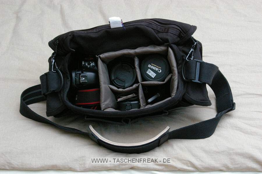 DOMKE F2\n\nFoto und Text von Lennart Wiedemuth - VIELEN DANK!\n\nKommentar:\n\nHallo Jörg,\neine neue Tasche ein neuer Bericht an dich ;).\n\nAlso ich habe mir die Domk F-2 in den USA bei Calumet für 124.99$ gekauft und zusätzlich noch ein Shoulderpad für 18.99$.\nDas Pad erleichtert das tragen um WELTEN um nicht von Galaxien zu sprechen ;). Wirklich sehr angenehm die Sache.\n\nGekauft wurde die Tasche für Documentary und Photojournalism damit man das was man braucht mit nehmen und auch schnell parat hat.\nIch fülle sie zu 50% wie auf Bild zwei (1DII, 17-40 F4, 50mm F1.4, Akku, Cleaning, Ipod und ein Block) in weiteren 40% wird die 1DII durch die 1N ersetzt und ein paar Filme kommen dazu.\nMan kann sie allerdings auch komplett voll machen, zum Beispiel für Sport oder ähnliches mit einer Remote PW's etc etc.\n\nDer "Deckel" lässt sich schnell über zwei Klipse öffnen und schliessen, kann aber auch offen gelassen werden denn das Klett hält recht gut.\nDie 2 kleinen Fronttaschen sind für meinen Geschmack etwas zu klein (mein 550EX geht da nicht rein) dafür ist die kleine Außentasche auf der hinterseite der Tasche sehr praktisch, für Handys, Stifte oder Zeitungen.\n\nBesten Gruß,\nLennart