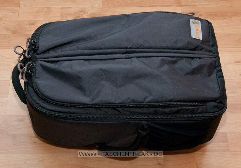 GURAGEAR KIBOKO\n\nFoto und Kommentar von Thorsten - VIELEN DANK!\n\nKommentar:\n\nDie GuraGear Kiboko:\n\nEs handelt sich um eine Tasche, die in der Mitte geteilt ist. Diese \nkoennen wie ein Schmetterling einzeln geöffnet werden. In eine Seite \npasst ein Nikon 200-400 mit Pro Kamera (dabei ist noch etwa 5 cm Platz). \nGeli ist verkehrt herum. Zur Groessenangabe habe ich ein 30cm Massstab \nhinzu gelegt.\n\nBesonderheiten: Die Schultergurte lassen sich verdecken. So kann die \nTasche besser in einem Flugzeug verstaut werden. Die Maße entsprechen \nden internationalen Fluglinienbestimmungen, und die Tasche passt somit \nin die Verstauungsmöglichkeiten beim Flugzeug über dem Kopf.\n\nDie Schulterriemen sind nicht so stark gepolstert wie z.B. beim Tamrac \nExpedition. Somit ist die Tasche aber viel leichter. Dennoch lässt Sie \nsich aber gut tragen.\n\nRechts gibt es eine Möglichkeit ein Stativ zu befestigen. Ist aber eher \nklein ausgefallen.\n\nLinks ist eine Tasche, in der eine Flasche verstaut werden kann.\n\nZusammenfassung: Die Tasche ist eher leichter ausgefallen. Hochwertige \nMaterialien. Reissverschlüsse etwas klein. Scheinen aber stabil zu sein. \nACHTUNG! Man muss höllisch aufpassen, dass man die Tasche nicht voll \npackt! Es würden ja auf beide Seiten eine grosse PRO Linse passen! Denn \nsonst kann man Sie nicht mehr tragen. Grins.