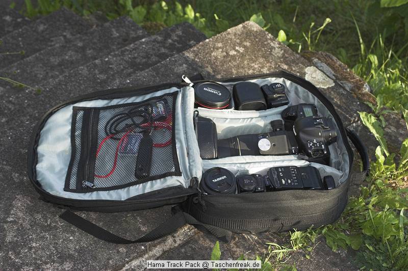 Foto von Horst Kretzschmar - DANK DAFR!\n\nKommentar des Nutzers:\n\nWeil die Composition sehr seltsam ist, hier mal meine aktuelle Outdoor-Tasche, Bilder vom Hama Track-Pack Rucksack sind bereits in der Datenbank enthalten. Das Teil ist deshalb interessant, weil es effektiv 15 cm Innenhhe (30x15x33 cm) bietet, wodurch eine 1er tatschlich gut reinpat - ohne zu "spannen" wie in den anderen kleinen Lsungen von Lowepro oder Tamrac. Weiterhn schn: das Teil wiegt nur 1150 g, noch schner der Preis, 29,95 . Der Haken: das Teil ist ziemlich dnn, die Innenteile neigen zum Losreien, was man aber mit Nadel und Faden ggf. korrigieren kann. Aber es geht eine menge rein, besonders das Sigma 150 am Body mit angeschraubter Kurzsonnenblende, dazu im Hauptteil 3 x 420 EX mit Bouncern, 90 mm Tamron-Macro und 17-40L. Das reicht mir fr das "Normale".