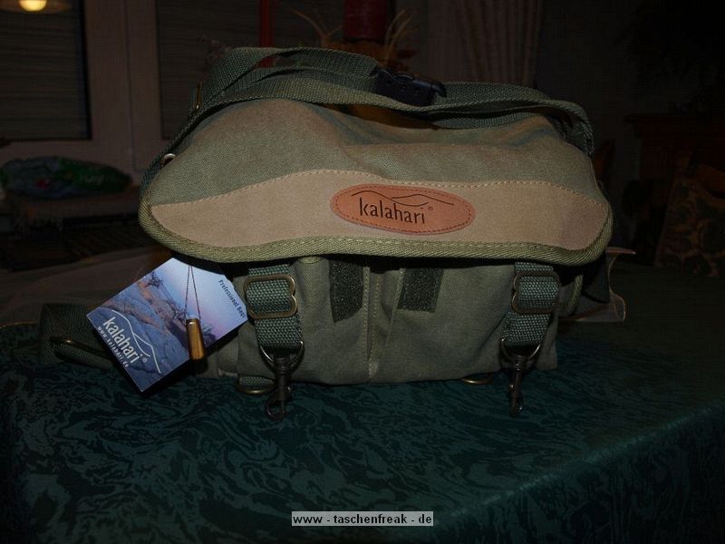 KALAHARI K-11\n\nFoto und Text von Daniel Schlueter - VIELEN DANK!\n\nKommentar:\n\nHallo\n\nanbei ein paar Bilder der Kalahari K-11, dem kleineren Bruder der K-12\n\nDas Hauptfach kann man entweder mit einem Doppelreissverschluss zumachen oder wenn es schnell gehen muss per berwurfdeckel und Klettverschluss verschlossen werden. Die Tasche besitzt  Auentaschen fr zubehr wie Akku, Filter oder Ladegerte, eine flache Rcktasche fr Papierkram und ein Netzfach beim Deckel. Der Umhngegurt ist verstellbar, die Schulterpolsterung abnehmbar. Zudem gibt es einen kurzen Handtragegurt. Deckelverschluss erfolgt ber 2 Metallkarabiner.\n\nBild 1:\n\nDie Vorderseite der Tasche. Hier sieht man schn die Metallkarabiner zum Verschluss\n\nBild 2:\n\nSiehe Bild 1...etwas heller ausgeleuchtet\n\nBild 3:\n\nInnenansicht der Tasche. Es gibt sehr viele kleine 'Einlegebden' mit denen das Hauptfach weiter unterteilt werden kann. Aus Grnden der Flexibilitt habe ich bereits hier die Hlfte der Fcher (Klettverschluss) entfernt. \n\nBild 4:\n\nDas hochwichtige Tigerauge das jeder Tasche beiliegt: Zitat: Schon bei den Arabern und alten Griechen beliebt, schtzte man sich spter im Mittelalter druch das Tragen eines Tigerauges gegen den 'bsen Blick' und gegen verwnschungen. Als Heilstein soll es den eigenen Blick schrfen und zu Kreativitt verhelfen.\n\nBild 5:\n\nDer gut gepolsterter Tragegurt. Was aussieht wie ein Materialfehler ist in Wirklichkeit der Klettverschluss. Ich sehe allerdings keinen grund diese Polsterung abnehmen zu wollen.\n\nBild 6:\n\nInnenleben. Die hier abgebildete Kamera ist nicht die, fr die ich die Tasch gekauft habe. Zu sehen ist hier die grere E-330 (nutze die E-520) mit dem wuchtigen 14-54mm Objektiv. Darber liegt eine Sonnenblende und links im Bild ein 35mm Makroobjektiv und ein 40-150mm Zoom-Objektiv.\nVorne finden USB Kabel sowie Ladegert Platz. Wer geschickt packt, bekme auch ein kleines Tisch-Stativ mit untergrbracht.\n\nich wnsche viel Spass beim Einstellen und bin sehr dankbar, dass es eure Seite gibt.!\n\nmfg Daniel Schlter