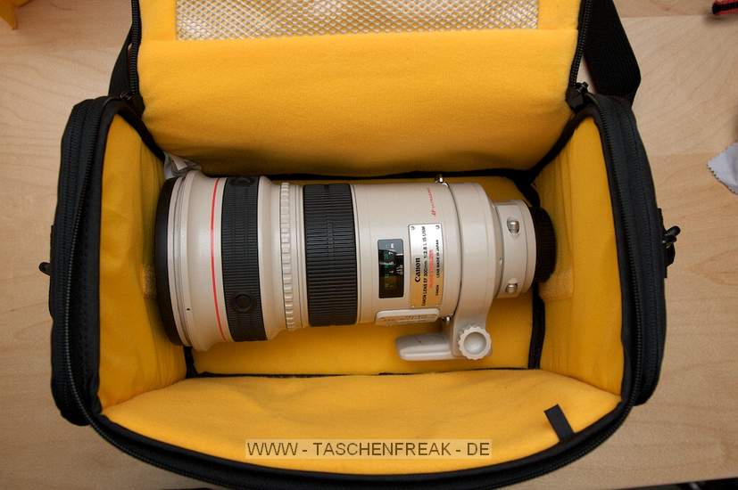 KATA DC-445\n\nFoto und Text von einem Anonymen User - VIELEN DANK!\n\nKommentar:\n\nKata DC 445\n\nDa ich sowohl einen großen Rucksack (Lowepro Mini Trekker AW), als eine (sehr) kleine Tasche (Lowepro Rezo 170AW) habe, suchte ich eine Tasche für ein oder zwei Gehäuse mit 3 bis 4  Objektiven von 28mm bis 135mm Brennweite. Fast jeder Hersteller bietet in diesem Segment eine Lösung an.\nDie Kata DC 445 ist kein Platzwunder mit unzähligen Täschchen, wie man es von Lowepro kennt, das muss sie aufgrund meiner gestellten Anforderungen auch nicht sein. Sie bietet lediglich im Deckel und in zwei weiteren Taschen an den Kopfenden Platz, um Zubehör zu verstauen.  \nDas Bild mit dem 300er zeigt, wie viel Platz die Tasche bietet. Wie die Fotos zeigen, passen in die Tasche zwei Gehäuse, mehrere Objektive und Zubehör (10KB Filme). Was die Fotos allerdings nicht zeigen ist, dass der von mir verwendeten Packweise das oben auf liegende Gehäuse mit angesetztem Objektiv nicht ganz in die Tasche passen, der Deckel also etwas über das Gehäuse "gezerrt" werden muss. Dabei sollte die Kamera unbedingt mit einem Tuch abgedeckt werden, da sonst der Reisverschluss das Display zu zerkratzen droht, da er ungeschützt ist (Ich denke hier hätte Lowepro eine bessere Lösung angeboten).\nAuch ist die Anbringung der Kopftaschen problematisch, weil die Gurte über die Tasche gelegt wurden und somit bei hohem Gewicht der Tasche die Kopftaschen zusammengedrückt werden. Im Gebrauch könnten diese also nur schwer zu öffnen sein.\nDie Tasche wiegt mit dem gezeigten Inhalt 5.3 Kilo, die sich noch bequem tragen ließen, auf längere Wanderungen ist die Tasche jedoch nicht einsetzen, hier sollte ein Rucksack bevorzugt werden.\n\nNachtrag: Aufgrund der von mir genannten Mängeln habe ich auf die Lowepro Nova 190AW zurückgegriffen, sie bietet die selben Eigenschaften wie die DC 445, jedoch ohne die Mängel zu einem Aufpreis von ca. 20€.