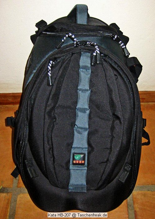 KATA HB-207\n\nFoto von Michael Reiff - VIELEN DANK!\n\nKommentar des Nutzers:\n\nGroesszuegig gepackt ohne irgendwtwas quetschen zu muessen.\n\nBeladung ist, glaube ich ersichtlich.\n\nder Rucksack verfuegt ueber ein Laptopfach fuer 17" incl. eines anklettbaren Behaelters fuer 8 CD/DVD und eines Teilers.\n\nDas abgebildete Zubehoer von oben nach unten:\n\nZusatzlicher Stativhalter, kann in der Mitte/aussen am Rucksack angebracht werden, damit das Stativ mittig getragen werden kann. Ragt dann aber nach unten aus (wie beim Lowe Pro Compu Trekker)\nDas Stativ kann aber seitlich am Rucksack in den offenen Taschen bequem angebracht werden (Strap liegt bei), die andere Tasche fasst dann eine Wasserflasche.\n\n2 Straps, damit koennen die mitgelieferten Kamerahalterungen zu einem Nackenband verbunden werden.\n\nZwei klettbare Zubehoerbeutel und rechts das ist die mitgelieferte Regenhuelle.\n\nDarunter sind die Kamerastrapsr, sie werden an der Kamera (wie Euer Nackengurt) befestigt und mit Hilfe von 2 Karabinern an den Trageriemen des Rucksacks befestigt,\nsomit haengt die Kamera vor dem Bauch, aber am Rucksack (was immer das auch bringen mag).\n\nDer Rucksack wiegt leer 3,7 kgs mit allem mitgelieferten Zubehoer. Aufgrund seiner Verstellmeoglichkeiten in der Hoehe, auch fuer grosse Leute bequem zu tragen. Der Beckengurt verfuegt\nuber zwei Falten, somit kann er komplett weggeklappt werden, kann aber auch ganz aus der Halterung genommen werden.\n\nEs gibt auch Minuspunkte: Der Handgriff ist an der oberen Klappe befestigt und somit wird der Rucksack vom Reissverschluss getragen...ich werde Ihn wohl direkt abmachen, damit man nicht in Versuchung kommt.\nda sollte Kata nochmals nachbessern.