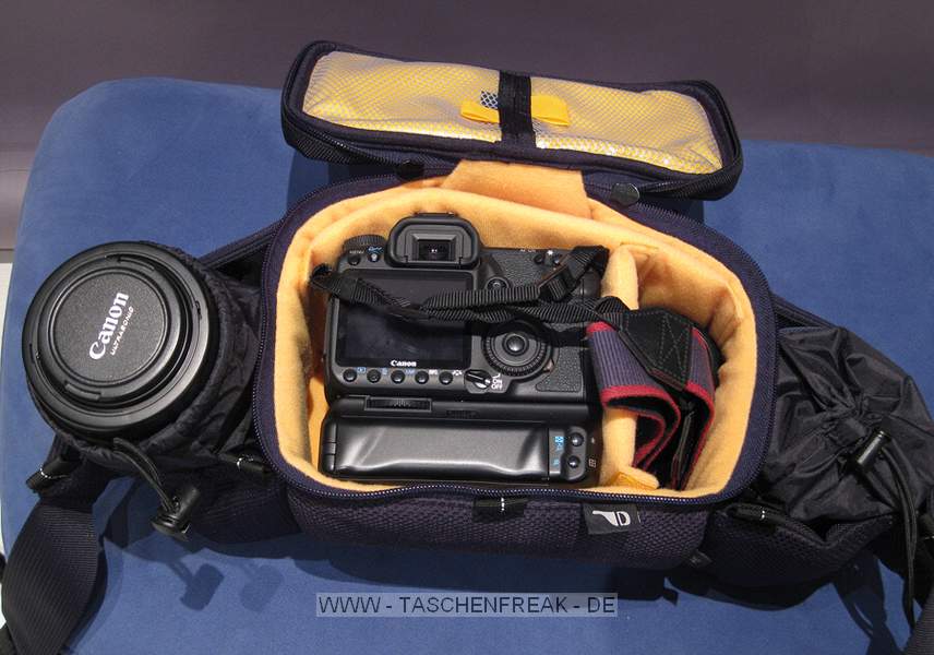 KATA W-92\n\nFoto und Text von Tobias Etzer - VIELEN DANK!\n\nKommentar:\n\nHi, endlich kann ich auch mal was zu deiner genialen Seite beitragen!\nAlso, die Kata W-92 kann als Bauchtasche oder, dank dem mitgelieferten Gurt, auch als Schultertasche getragen werden.\nAußerdem dabei - ein praktischer Regenschutz, hält gut dicht und ist auch sehr durchdacht mit Klettaussparungen für den Bauchgurt.\nMan bekommt auch einiges unter, ich habe verstaut:\nEOS40D + BG + EF-S 18-55IS + Sigma 50 1,4 HSM + Tamron 90 2,8 Macro + EF 70-200 4L + Akkus und Kleinkram, in die Außentasche und die kleinen Taschen am Gurt bekommt man sicherlich noch mehr Kleinkram.\nVon der Verarbeitung her wirkt die Tasche sehr wertig, die Verschlüsse sind zwar Plastik, wirken aber stabil. Die Reißverschlüsse laufen ebenfalls sehr sauber. Die Polsterung kommt mir, zumindest im Hauptfach, auch ausreichend stark vor, bei den beiden Außenköchern bin ich mir noch nicht so sicher.\nIngesamt bin ich sehr angetan von der Tasche.\nIch hoffe ich konnte weiterhelfen,\nlG Tobias