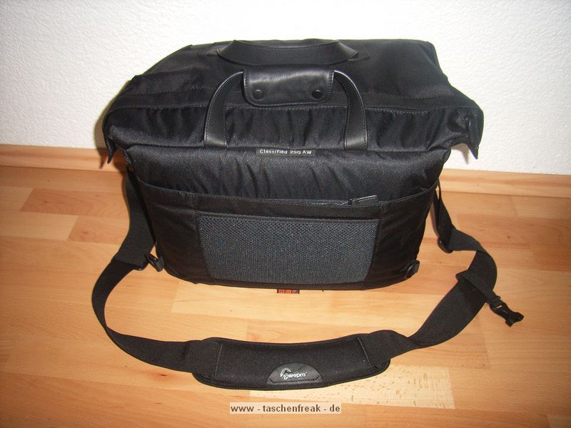 LOWEPRO CLASSIFIED 250AW\n\nFoto und Text von Ralf Steck - VIELEN DANK!\n\nKommentar:\n\nHallo Jörg,\n\nnachdem ich monatelang Deine Seiten durchgesehen habe, hier mal ein Beitrag von mir: Fotos zur Lowepro Classified 250AW. \n\nDie Tasche ist schon sehr groß, aber es geht eben auch viel rein. Ich bin freier Journalist und suchte nach einer Tasche für Laptop + Fotoausrüstung + Schreibmappe + Platz für Unterlagen, beispielsweise wenn ich auf Pressekonferenzen gehe. Im Kamerafach ist noch einiges an Platz, beispielsweise für ein Buch und Notklamotten, wenn’s mal wieder mit dem Flugzeug irgendwohin geht. Die Tasche ist allerdings offiziell zu groß fürs Handgepäck, gepackt wie auf den Bildern zu sehen sind die Maße 45 x 29 x 29, wobei es möglich sein sollte, die Tasche auf Handgepäcktaugliche 20cm Breite zu drücken, wenn die Schreibmappe draußen ist. Auf der Reise ist die Lasche fürs anbringen am Koffertrolley praktisch. Hinten dran ist nochmal ein frei zugängliches, mit Reißverschluss gesichertes Fach dran, in das A4-Unterlagen passen, aber beispielsweise auch Bordkarten, Pass usw. griffbereit und trotzdem sicher transportiert werden können.\n\nDas Fotofach und die Trenner sind komplett mit dem weichen Klettstoff belegt, so dass man die Tasche völlig frei einrichten kann, beispielsweise auch zweistöckig. Das EF-S 55-250 passt mit aufgesetzter Geli aufrecht rein, ebenso der Blitz (Canon Speedlite 580 EX-II) mit Bouncer drauf. Zwei Microfasertücher, die an kleinen, klettbaren Taschen sitzen, schützen die Kamera.\n\nDas linke vordere Fach ist innen mit samtartigem Stoff gefüttert, so dass der IPod schön sicher transportiert werden kann. Es ist noch eine Rolltasche für bis zu 9 CF-Karten dabei, die ich aber nicht benutze.\n\nDie Tasche sieht, wie ich finde, elegant, anzugtauglich und nicht fototaschenmäßig aus, auch wenn sie durch die große Tiefe schon etwas sperrig wirkt. Sie lässt sich angenehm tragen und ich habe sie auch schon mit dem Zusatzgurt auf dem Rad getragen. Dabei fällt auf, dass das Schulterpolster fest am Gurt ist, wenn man die Tasche auf den Rücken schiebt, hat man das Polster an der Brust statt oben auf der Schulter.\n\n--\nViele Grüße vom Bodensee,\nRalf Steck - Die Textwerkstatt