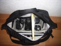 LOWEPRO CLASSIFIED 250AW\n\nFoto und Text von Ralf Steck - VIELEN DANK!\n\nKommentar:\n\nHallo Jrg,\n\nnachdem ich monatelang Deine Seiten durchgesehen habe, hier mal ein Beitrag von mir: Fotos zur Lowepro Classified 250AW. \n\nDie Tasche ist schon sehr gro, aber es geht eben auch viel rein. Ich bin freier Journalist und suchte nach einer Tasche fr Laptop + Fotoausrstung + Schreibmappe + Platz fr Unterlagen, beispielsweise wenn ich auf Pressekonferenzen gehe. Im Kamerafach ist noch einiges an Platz, beispielsweise fr ein Buch und Notklamotten, wenns mal wieder mit dem Flugzeug irgendwohin geht. Die Tasche ist allerdings offiziell zu gro frs Handgepck, gepackt wie auf den Bildern zu sehen sind die Mae 45 x 29 x 29, wobei es mglich sein sollte, die Tasche auf Handgepcktaugliche 20cm Breite zu drcken, wenn die Schreibmappe drauen ist. Auf der Reise ist die Lasche frs anbringen am Koffertrolley praktisch. Hinten dran ist nochmal ein frei zugngliches, mit Reiverschluss gesichertes Fach dran, in das A4-Unterlagen passen, aber beispielsweise auch Bordkarten, Pass usw. griffbereit und trotzdem sicher transportiert werden knnen.\n\nDas Fotofach und die Trenner sind komplett mit dem weichen Klettstoff belegt, so dass man die Tasche vllig frei einrichten kann, beispielsweise auch zweistckig. Das EF-S 55-250 passt mit aufgesetzter Geli aufrecht rein, ebenso der Blitz (Canon Speedlite 580 EX-II) mit Bouncer drauf. Zwei Microfasertcher, die an kleinen, klettbaren Taschen sitzen, schtzen die Kamera.\n\nDas linke vordere Fach ist innen mit samtartigem Stoff gefttert, so dass der IPod schn sicher transportiert werden kann. Es ist noch eine Rolltasche fr bis zu 9 CF-Karten dabei, die ich aber nicht benutze.\n\nDie Tasche sieht, wie ich finde, elegant, anzugtauglich und nicht fototaschenmig aus, auch wenn sie durch die groe Tiefe schon etwas sperrig wirkt. Sie lsst sich angenehm tragen und ich habe sie auch schon mit dem Zusatzgurt auf dem Rad getragen. Dabei fllt auf, dass das Schulterpolster fest am Gurt ist, wenn man die Tasche auf den Rcken schiebt, hat man das Polster an der Brust statt oben auf der Schulter.\n\n--\nViele Gre vom Bodensee,\nRalf Steck - Die Textwerkstatt
