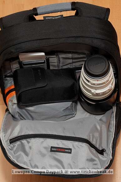 Foto von Jrg Langer\n\nRelativ groes Daypack Fach oberhalb des Kamerafaches. In diesem Fall der Beladung steht hier hochkannt ein Canon 100-400, daneben eine kleine Tasche mit Notebook Netzteil und Kabel, Steckernetzteil fr XDRIVE und Sandisk Card Reader, darber ein Blitzgert in der originalen Hlle. In der vorderen inneren Reisverschlusstasche ist das XDRIVE und die Speicherkartenmappen enthalten.