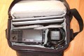 Foto von Jörg Langer\n\nKommentar des Nutzers:\n\nHier ein paar Bilder einer Fototasche in etwas ungewöhlicher Verwendung.\n\nHier sind ein Subnotebook und ein Beamer inkl. Netzteilen, Card Reader, externer Festplatte, Netzteile und Fernbedienung für den Beamer untergebracht. Auch die unterwegs so oft vermisste dreifach Steckdose mit Kabel passt gerade so rein.\n\nDas ganze ist sehr leicht und angenehm zu tragen.\n\nEine AllWetter Hülle hat die EX180 nicht, aber man schleppt einen Beamer und ein kleines Notebook eh meistens nicht durch Wind und Wetter und einen kleinen Schauer an Regen kann die Tasche auch so sehr gut abhalten.\n\nIn der Fotoverwendung passt her auch eine Canon 1D mit 24-105L IS und ein Blitzgerät rein - die ideale Tasche für den kleinen Ausflug.