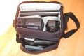 Foto von Jörg Langer\n\nKommentar des Nutzers:\n\nHier ein paar Bilder einer Fototasche in etwas ungewöhlicher Verwendung.\n\nHier sind ein Subnotebook und ein Beamer inkl. Netzteilen, Card Reader, externer Festplatte, Netzteile und Fernbedienung für den Beamer untergebracht. Auch die unterwegs so oft vermisste dreifach Steckdose mit Kabel passt gerade so rein.\n\nDas ganze ist sehr leicht und angenehm zu tragen.\n\nEine AllWetter Hülle hat die EX180 nicht, aber man schleppt einen Beamer und ein kleines Notebook eh meistens nicht durch Wind und Wetter und einen kleinen Schauer an Regen kann die Tasche auch so sehr gut abhalten.\n\nIn der Fotoverwendung passt her auch eine Canon 1D mit 24-105L IS und ein Blitzgerät rein - die ideale Tasche für den kleinen Ausflug.