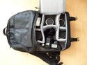 LOWEPRO FASTPACK 250\n\nFoto von Maximilian Schirmer - VIELEN DANK!\n\nKommentar des Nutzers:\n\nLowePro Fastpack 250\n\nDies ist mein erster Fotorucksack und auch meine erste Tasche von LowePro, das sollte ich eingangs vielleicht erwhnen, damit man meine Beurteilung einordnen kann. Ich werde den Fastpack im (Uni-)Alltag einsetzen, deshalb ist das Laptopfach Pflicht. Oft habe ich mich gergert, dass mein vorheriger Rucksack (Jack Wolfskin Brainstorm) die Kameraausrstung erst nach einiger Kramerei erreichbar machte. Dadurch habe ich so manche Chance auf ein schnes Foto verpasst und erhoffe mir vom Fastpack eine deutliche Verbesserung in Hinsicht auf den Schnellzugriff auf die Kamera.\n\nDer Rucksack ist extrem gut verarbeitet. Alle Reissverschlsse gehen butterweich und sind wohldurchdacht platziert. Das Laptopfach (fr Gerte bis 15.4 Zoll Widescreen) ist gut gepolstert, die Verwendung einer zustzlichen Neoprenhlle ist aber evtl. zu empfehlen.\n\nIm oberen Daypack-Fach lassen sich mhelos berlebensnotwendige Kleinigkeiten wie GPS-Logger, Taschenmesser, Netzteile, Notizbuch, Stifte oder Ausrstungsgegenstnde (kleines Stativ, Akkus, Speicherkarten, ...) verstauen. Eine Regenjacke findet auch ihren Platz. Der Boden, welcher das Daypack zur Fotoausrstung abtrennt, ist sehr solide und dick. Hier lassen sich also auch schwerere Gegenstnde unterbringen und eine ausgelaufene Flasche wird wohl nicht zu schnell die Kameraausrstung fluten. Auch wenn LowePro keine Regenhaube mitliefert, so ist eine entsprechende Unterbringungsmglichkeit im Deckel des Daypacks jedoch vorgesehen.\n\nDas Ausrstungsfach ist gestaltet wie bei den Slingshots und lsst sich recht variabel konfigurieren. Meine 5 Objektive (16/2.8, 28/2.8, 50/1.7, 135/2.8, 18-55 3.5~5.6) plus Kamera (Pentax K110D) und Blitz (Pentax AF360-FGZ) finden locker Platz, je nach Bauform lassen sich mindestens noch 3 bis 4 weitere verstauen. Auch ein Batteriegriff wrde kein Problem darstellen und passt noch locker an die verstaute Kamera.\n\nIch habe bemerkt, dass der Rucksack die Last extrem gut verteilt, die angenehm gepolsterten Trageriemen lassen auch lngere Touren mit voller Beladung zu, der Bauchgurt hilft zustzlich.\n\nNimmt man den Rucksack nur mit dem linken Trageriemen auf den Rcken, so lsst er sich in Slingshotmanier nach vorn ziehen und gestattet direkten Zugriff auf das Kamerafach.\n\nDer Fastpack 250 bietet zudem eine Vielzahl kleiner Fcher, die das sortierte Verstauen von Kleinteilen wie Akkus, Filter, Speicherkarten usw. extrem erleichtern. Mit meiner Ausstattung ist er wahrscheinlich nicht mal annhernd an der Grenze seiner Kapazitt.