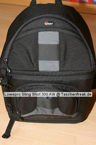 Lowepro Sling Shot 300AW\n\nFoto von Jörg Grunwald - DANKE DIR FÜR DIE BILDER!\n\nKommentar des Nutzers:\n\nDas Konzept der Lowepro Slingshot gefiel mir schon immer sehr gut, doch die Dinger waren zu klein.\n\nAm Freitag wurde dann meine neue Slingshot 300 AW von Directshopper.de geliefert.\n\nPlatz ist jetzt genug. Im Moment hab ich drin:\n\nNikon D2X, AF-S 70-200 / f2,8 VR, AF-S 18-200 VR, Tokina 12-24 ATX, Nikon SB 800 und noch ne Menge Kleinkram wie Fernauslöser, Filter, usw. Zwei weitere Objektive normaler Größe würden noch gut reinpassen.\n\nZusammen wiegt alles 5,8 KG. Das Gewicht ist mit der Slingshot noch sehr gut zu tragen, vor allem Dank des breiten gut gepolsterten Schultergurtes und der jetzt neu "richtigen" Beckengurte. Wenn man diese schön stramm einstellt, wird der Schultergurt ordentlich entlastet und die Tasche ist auch beim Laufen oder Klettern fest auf dem Rücken fixiert.\n\nFür den Zugriff auf die Cam braucht man nur den Verschluß des Beckengurtes zu lösen, die Tasche rutscht fast von selbst in die Zugriffsposition, dann noch schnell den gut laufenden Reißverschluß öffen und die Cam liegt griffbereit vor einem. Das ganze dauert mit ein bischen Übung max. 5 Sekunden.\n\nEntgegen der üblichen Beladung mit senkrecht stehenden Optiken im Hauptfach habe ich alles waagerecht übereinander, getrennt durch die Einteiler, in die Tasche gepackt. Das hat den Vorteil, das man in der Zugriffsposition an alle Teile von oben drankommt und die kleine Öffnung ausreicht. Das finde ich besser, als bei Zugriff auf die Objektive erst den ganzen Deckel öffnen zu müssen. Einmal besteht das Risiko dass etwas herausfällt, zum anderen kann man in Zugriffsposition diesen Bereich nur schlecht einsehen, da er von einem selbst abgewandt ist. \nBesonders praktisch finde ich das im Zugriffsbereich fest eingenähte Mikrofasertuch z.B. zur Reinigung von Linsen.\n\nIn Summe für mich eine sehr praktische, geräumige und gut zu tragende Tasche mittlerer Größe.\n\nXXX