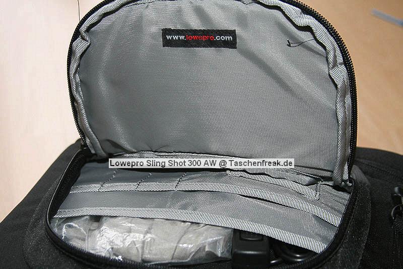 Lowepro Sling Shot 300AW\n\nFoto von Jörg Grunwald - DANKE DIR FÜR DIE BILDER!\n\nKommentar des Nutzers:\n\nDas Konzept der Lowepro Slingshot gefiel mir schon immer sehr gut, doch die Dinger waren zu klein.\n\nAm Freitag wurde dann meine neue Slingshot 300 AW von Directshopper.de geliefert.\n\nPlatz ist jetzt genug. Im Moment hab ich drin:\n\nNikon D2X, AF-S 70-200 / f2,8 VR, AF-S 18-200 VR, Tokina 12-24 ATX, Nikon SB 800 und noch ne Menge Kleinkram wie Fernauslöser, Filter, usw. Zwei weitere Objektive normaler Größe würden noch gut reinpassen.\n\nZusammen wiegt alles 5,8 KG. Das Gewicht ist mit der Slingshot noch sehr gut zu tragen, vor allem Dank des breiten gut gepolsterten Schultergurtes und der jetzt neu "richtigen" Beckengurte. Wenn man diese schön stramm einstellt, wird der Schultergurt ordentlich entlastet und die Tasche ist auch beim Laufen oder Klettern fest auf dem Rücken fixiert.\n\nFür den Zugriff auf die Cam braucht man nur den Verschluß des Beckengurtes zu lösen, die Tasche rutscht fast von selbst in die Zugriffsposition, dann noch schnell den gut laufenden Reißverschluß öffen und die Cam liegt griffbereit vor einem. Das ganze dauert mit ein bischen Übung max. 5 Sekunden.\n\nEntgegen der üblichen Beladung mit senkrecht stehenden Optiken im Hauptfach habe ich alles waagerecht übereinander, getrennt durch die Einteiler, in die Tasche gepackt. Das hat den Vorteil, das man in der Zugriffsposition an alle Teile von oben drankommt und die kleine Öffnung ausreicht. Das finde ich besser, als bei Zugriff auf die Objektive erst den ganzen Deckel öffnen zu müssen. Einmal besteht das Risiko dass etwas herausfällt, zum anderen kann man in Zugriffsposition diesen Bereich nur schlecht einsehen, da er von einem selbst abgewandt ist. \nBesonders praktisch finde ich das im Zugriffsbereich fest eingenähte Mikrofasertuch z.B. zur Reinigung von Linsen.\n\nIn Summe für mich eine sehr praktische, geräumige und gut zu tragende Tasche mittlerer Größe.\n\nXXX