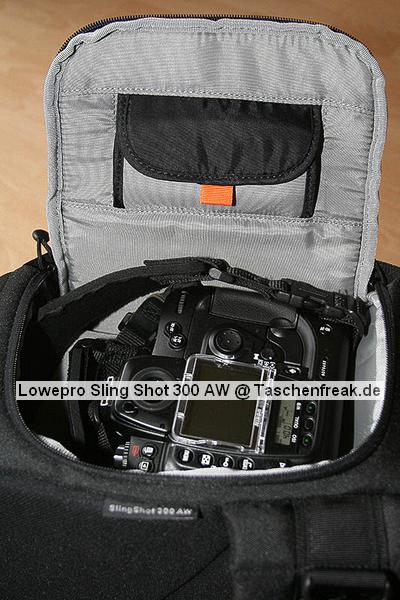 Lowepro Sling Shot 300AW\n\nFoto von Jrg Grunwald - DANKE DIR FR DIE BILDER!\n\nKommentar des Nutzers:\n\nDas Konzept der Lowepro Slingshot gefiel mir schon immer sehr gut, doch die Dinger waren zu klein.\n\nAm Freitag wurde dann meine neue Slingshot 300 AW von Directshopper.de geliefert.\n\nPlatz ist jetzt genug. Im Moment hab ich drin:\n\nNikon D2X, AF-S 70-200 / f2,8 VR, AF-S 18-200 VR, Tokina 12-24 ATX, Nikon SB 800 und noch ne Menge Kleinkram wie Fernauslser, Filter, usw. Zwei weitere Objektive normaler Gre wrden noch gut reinpassen.\n\nZusammen wiegt alles 5,8 KG. Das Gewicht ist mit der Slingshot noch sehr gut zu tragen, vor allem Dank des breiten gut gepolsterten Schultergurtes und der jetzt neu "richtigen" Beckengurte. Wenn man diese schn stramm einstellt, wird der Schultergurt ordentlich entlastet und die Tasche ist auch beim Laufen oder Klettern fest auf dem Rcken fixiert.\n\nFr den Zugriff auf die Cam braucht man nur den Verschlu des Beckengurtes zu lsen, die Tasche rutscht fast von selbst in die Zugriffsposition, dann noch schnell den gut laufenden Reiverschlu ffen und die Cam liegt griffbereit vor einem. Das ganze dauert mit ein bischen bung max. 5 Sekunden.\n\nEntgegen der blichen Beladung mit senkrecht stehenden Optiken im Hauptfach habe ich alles waagerecht bereinander, getrennt durch die Einteiler, in die Tasche gepackt. Das hat den Vorteil, das man in der Zugriffsposition an alle Teile von oben drankommt und die kleine ffnung ausreicht. Das finde ich besser, als bei Zugriff auf die Objektive erst den ganzen Deckel ffnen zu mssen. Einmal besteht das Risiko dass etwas herausfllt, zum anderen kann man in Zugriffsposition diesen Bereich nur schlecht einsehen, da er von einem selbst abgewandt ist. \nBesonders praktisch finde ich das im Zugriffsbereich fest eingenhte Mikrofasertuch z.B. zur Reinigung von Linsen.\n\nIn Summe fr mich eine sehr praktische, gerumige und gut zu tragende Tasche mittlerer Gre.\n\nXXX