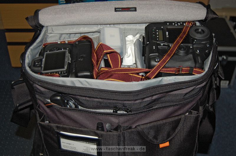 LOWEPRO STEALTH REPORTER D650\n\nFoto und Kommentar von Jrg Langer - www.taschenfreak.de\n\nKommentar:\n\nSensationelle Tasche!\n\nWer Amerikanische Fototaschen wie Domke und Think Tank Photo mag wird auch diese Tasche lieben!\n\nSie ist ein Raumwunder und dennoch weich und am Krper gut zu tragen.\n\nEin Marketinggag bzw. Witz ist das Deckelffnungsthema - bzw. der Reisverschluss im Deckelfach durch den man die Cam ohne generelles ffnen des kompletten Deckels die Cam entnehmen knnen soll. Da geht m.E nur eine ganz kleine DSLR oder eher eine kompakte Cam durch. Eine anspruchsvolle Cam mit einem Objektiv geht da nur mit "Zuchteln" und "Fuchteln" hindurch.\n\nDie Inneneinteilungen sind flexiben und gut nutzbar.\n\nAuch eine groe Cam wie eine 1er Canon oder eine Nikon D3 mit angesetztem 70-200 2.8 sind stehend darin mglich. Das ist der groe Unterschied zu sehr vielen anderen Taschen auf dem Markt, bei denen genau das nicht mglich ist.\n\nDer Tragegurt ist gut gepolstert aber m.E. nicht so gut und brauchbar. Da ist ein Domke Gurt mit US Post Office Shoulder Pad oder ein Neopren Gurt wie der Aircell Taschengurt wesentlich besser um das Gewicht der beladenen Tasche auf der Schulter zu verteilen und ertrglich zu machen.\n\nMit dem Trolly - EInkaufswagen eine sehr praktikable Sache diese Tasche.\n\nMit dem Tamrac S-114 Rucksackgeschirr brigens auch bequem auf dem Rcken zu tragen.\n\nIch hoffe es hilft Euch - Euer Taschenfreak