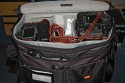 LOWEPRO STEALTH REPORTER D650\n\nFoto und Kommentar von Jrg Langer - www.taschenfreak.de\n\nKommentar:\n\nSensationelle Tasche!\n\nWer Amerikanische Fototaschen wie Domke und Think Tank Photo mag wird auch diese Tasche lieben!\n\nSie ist ein Raumwunder und dennoch weich und am Krper gut zu tragen.\n\nEin Marketinggag bzw. Witz ist das Deckelffnungsthema - bzw. der Reisverschluss im Deckelfach durch den man die Cam ohne generelles ffnen des kompletten Deckels die Cam entnehmen knnen soll. Da geht m.E nur eine ganz kleine DSLR oder eher eine kompakte Cam durch. Eine anspruchsvolle Cam mit einem Objektiv geht da nur mit "Zuchteln" und "Fuchteln" hindurch.\n\nDie Inneneinteilungen sind flexiben und gut nutzbar.\n\nAuch eine groe Cam wie eine 1er Canon oder eine Nikon D3 mit angesetztem 70-200 2.8 sind stehend darin mglich. Das ist der groe Unterschied zu sehr vielen anderen Taschen auf dem Markt, bei denen genau das nicht mglich ist.\n\nDer Tragegurt ist gut gepolstert aber m.E. nicht so gut und brauchbar. Da ist ein Domke Gurt mit US Post Office Shoulder Pad oder ein Neopren Gurt wie der Aircell Taschengurt wesentlich besser um das Gewicht der beladenen Tasche auf der Schulter zu verteilen und ertrglich zu machen.\n\nMit dem Trolly - EInkaufswagen eine sehr praktikable Sache diese Tasche.\n\nMit dem Tamrac S-114 Rucksackgeschirr brigens auch bequem auf dem Rcken zu tragen.\n\nIch hoffe es hilft Euch - Euer Taschenfreak