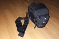 Foto von Jrg Langer\n\nKommentar des Nutzers:\n\nDie Toploader Serie von Lowepro ist sehr gut und hochwertig verarbeitet.\n\nIn dieses hier gezeigte Modell kann man Problemlos eine groe DSLR wie eine Canon 1D und ein All Round Zoom hineinpacken. Eine Schnellwechselplatte oder ein sogenannter L-Winkel passen auch geradeso noch hinein. Die Gegenlichtblende des Objektives sollte umgedreht montiert werden.\n\nIn der Vordertasche kann man entweder 2 groe Akkupacks oder einen mittelgroen Blitz reinpacken. Canon 420EX oder 430EX passen prima hinein, die groen 550EX oder 580EX sind etwa 1,5cm zu lang fr diese Vordertasche.\n\nAn den Seiten finden sie die Lowepro Sliplock Schlaufen an denen man gut seiten taschen oder eine Getrnkeflasche anbringen kann.\n\nIch setze hier gerne die LP D-Res25 an in der sich mein Polfilter udn 2 Akkupacks und ein paar Ersatzspeichercards befinden und auf der anderen Seite das kleine LP D-Res 8-S in dem sich meine Immerdabei Cam die Fuji F10 befindet.\n\nEine AW (Allwetterhlle) bzw. der Regenschutz befindet sich in der Fronttasche und kann auch wie abgebildet schnell und unkompliziert angebracht werden.\n\nFazit: Eine klasse Tasche fr das leichte "Sturmgepck". Bei mir gerne fr Feuerwehreinstze genutzt, weil ich da nichts auer meiner 1D und dem 24-105L und ab und zu einem kl. Blitz brauche.