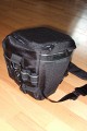 Foto von Jrg Langer\n\nKommentar des Nutzers:\n\nDie Toploader Serie von Lowepro ist sehr gut und hochwertig verarbeitet.\n\nIn dieses hier gezeigte Modell kann man Problemlos eine groe DSLR wie eine Canon 1D und ein All Round Zoom hineinpacken. Eine Schnellwechselplatte oder ein sogenannter L-Winkel passen auch geradeso noch hinein. Die Gegenlichtblende des Objektives sollte umgedreht montiert werden.\n\nIn der Vordertasche kann man entweder 2 groe Akkupacks oder einen mittelgroen Blitz reinpacken. Canon 420EX oder 430EX passen prima hinein, die groen 550EX oder 580EX sind etwa 1,5cm zu lang fr diese Vordertasche.\n\nAn den Seiten finden sie die Lowepro Sliplock Schlaufen an denen man gut seiten taschen oder eine Getrnkeflasche anbringen kann.\n\nIch setze hier gerne die LP D-Res25 an in der sich mein Polfilter udn 2 Akkupacks und ein paar Ersatzspeichercards befinden und auf der anderen Seite das kleine LP D-Res 8-S in dem sich meine Immerdabei Cam die Fuji F10 befindet.\n\nEine AW (Allwetterhlle) bzw. der Regenschutz befindet sich in der Fronttasche und kann auch wie abgebildet schnell und unkompliziert angebracht werden.\n\nFazit: Eine klasse Tasche fr das leichte "Sturmgepck". Bei mir gerne fr Feuerwehreinstze genutzt, weil ich da nichts auer meiner 1D und dem 24-105L und ab und zu einem kl. Blitz brauche.