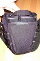 Foto von Jrg Langer\n\nKommentar des Nutzers:\n\nDie Toploader Serie von Lowepro ist sehr gut und hochwertig verarbeitet.\n\nIn dieses hier gezeigte Modell kann man Problemlos eine groe DSLR wie eine Canon 1D und ein All Round Zoom hineinpacken. Eine Schnellwechselplatte oder ein sogenannter L-Winkel passen auch geradeso noch hinein. Die Gegenlichtblende des Objektives sollte umgedreht montiert werden.\n\nIn der Vordertasche kann man entweder 2 groe Akkupacks oder einen mittelgroen Blitz reinpacken. Canon 420EX oder 430EX passen prima hinein, die groen 550EX oder 580EX sind etwa 1,5cm zu lang fr diese Vordertasche.\n\nAn den Seiten finden sie die Lowepro Sliplock Schlaufen an denen man gut seiten taschen oder eine Getrnkeflasche anbringen kann.\n\nIch setze hier gerne die LP D-Res25 an in der sich mein Polfilter udn 2 Akkupacks und ein paar Ersatzspeichercards befinden und auf der anderen Seite das kleine LP D-Res 8-S in dem sich meine Immerdabei Cam die Fuji F10 befindet.\n\nEine AW (Allwetterhlle) bzw. der Regenschutz befindet sich in der Fronttasche und kann auch wie abgebildet schnell und unkompliziert angebracht werden.\n\nFazit: Eine klasse Tasche fr das leichte "Sturmgepck". Bei mir gerne fr Feuerwehreinstze genutzt, weil ich da nichts auer meiner 1D und dem 24-105L und ab und zu einem kl. Blitz brauche.