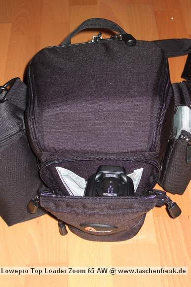 Foto von Jrg Langer\n\nKommentar des Nutzers:\n\nDie Toploader Serie von Lowepro ist sehr gut und hochwertig verarbeitet.\n\nIn dieses hier gezeigte Modell kann man Problemlos eine groe DSLR wie eine Canon 1D und ein All Round Zoom hineinpacken. Eine Schnellwechselplatte oder ein sogenannter L-Winkel passen auch geradeso noch hinein. Die Gegenlichtblende des Objektives sollte umgedreht montiert werden.\n\nIn der Vordertasche kann man entweder 2 groe Akkupacks oder einen mittelgroen Blitz reinpacken. Canon 420EX oder 430EX passen prima hinein, die groen 550EX oder 580EX sind etwa 1,5cm zu lang fr diese Vordertasche.\n\nAn den Seiten finden sie die Lowepro Sliplock Schlaufen an denen man gut seiten taschen oder eine Getrnkeflasche anbringen kann.\n\nIch setze hier gerne die LP D-Res25 an in der sich mein Polfilter udn 2 Akkupacks und ein paar Ersatzspeichercards befinden und auf der anderen Seite das kleine LP D-Res 8-S in dem sich meine Immerdabei Cam die Fuji F10 befindet.\n\nEine AW (Allwetterhlle) bzw. der Regenschutz befindet sich in der Fronttasche und kann auch wie abgebildet schnell und unkompliziert angebracht werden.\n\nFazit: Eine klasse Tasche fr das leichte "Sturmgepck". Bei mir gerne fr Feuerwehreinstze genutzt, weil ich da nichts auer meiner 1D und dem 24-105L und ab und zu einem kl. Blitz brauche.
