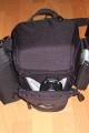 Foto von Jrg Langer\n\nKommentar des Nutzers:\n\nDie Toploader Serie von Lowepro ist sehr gut und hochwertig verarbeitet.\n\nIn dieses hier gezeigte Modell kann man Problemlos eine groe DSLR wie eine Canon 1D und ein All Round Zoom hineinpacken. Eine Schnellwechselplatte oder ein sogenannter L-Winkel passen auch geradeso noch hinein. Die Gegenlichtblende des Objektives sollte umgedreht montiert werden.\n\nIn der Vordertasche kann man entweder 2 groe Akkupacks oder einen mittelgroen Blitz reinpacken. Canon 420EX oder 430EX passen prima hinein, die groen 550EX oder 580EX sind etwa 1,5cm zu lang fr diese Vordertasche.\n\nAn den Seiten finden sie die Lowepro Sliplock Schlaufen an denen man gut seiten taschen oder eine Getrnkeflasche anbringen kann.\n\nIch setze hier gerne die LP D-Res25 an in der sich mein Polfilter udn 2 Akkupacks und ein paar Ersatzspeichercards befinden und auf der anderen Seite das kleine LP D-Res 8-S in dem sich meine Immerdabei Cam die Fuji F10 befindet.\n\nEine AW (Allwetterhlle) bzw. der Regenschutz befindet sich in der Fronttasche und kann auch wie abgebildet schnell und unkompliziert angebracht werden.\n\nFazit: Eine klasse Tasche fr das leichte "Sturmgepck". Bei mir gerne fr Feuerwehreinstze genutzt, weil ich da nichts auer meiner 1D und dem 24-105L und ab und zu einem kl. Blitz brauche.