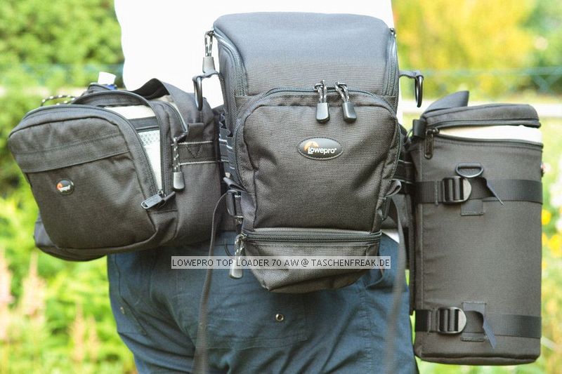 LOWEPRO TOP LOADER 70 AW\n\nFoto von Martin Adler - VIELEN DANK!\n\nKommentar des Nutzers:\n\nTopLoader 70 AW:\nDa passt die 350D mit Batteriegriff + EF 100-400 mit umgekehrt angesetzter Geli rein. In die Tasche vorne passt z.B. ein Blitz rein. Die Tasche vorne hat nach unten noch einen Klettverschluss um den Raum in die darunter liegende 'Verlängerung' platz zu schaffen.\nMit dabei ist ein gewohnt guter Schultergurt und der Chest Harness.