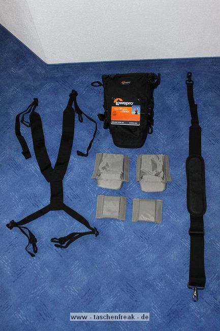 LOWEPRO - TOP LOADER ZOOM AW\n\nFoto von Peter Albrecht - VIELEN DANK!\n\nKommentar:\n\n- gekauft Januar 2009 (scheint auch berarbeitete Version zu sein gegenber dem Model, welches auch auf taschenfreak gezeigt wird)\n  neu: - Reisverschlu innen im Deckel hat jetzt eine Schutzkappe (Bild 06)\n       - SlipLock auf beiden Seiten (Bilder 02 und 04)\n\n- Beigaben:\n  - Schultergurt (Bild 05)\n  - Chest Harness (4 Kunststoffhaken) (Bild 05)\n      - Chest Harness, den man als extra Zubehr erwerben kann hat fr die oberen Ringe zwei Metallhaken\n      - Gurte lassen sich schnell und einfach verstellen\n      - keine Anleitung => erst mal experimentieren, aber man kriegs relativ schnell hin\n  - klitzekleine Anleitung fr die Tasche selbst (englisch / franzsisch / kein Deutsch)\n  - Werbeschild 30 Jahre Lowepro (ist dann wohl schon etwas lter) (Bild 01)\n\n- Innenraum mit 4 Trennern veriabel gestaltbar (Bilder 05, 07, 08 und 09)\n- beim 18-55mm Objektiv kann man problemlos das Ladegert fr die Akkus unter einem doppelten Boden verstauen (Bild 09)\n- die zwei groen Trenner haben noch seitliche Taschen fr Kleinzeugs (z.B. Akkus) (Bilder 05 und 08)\n- Zwei SlipLock Schlaufen (je eine links und rechts) (Bilder 02 und 04)\n- die oberen zwei Ringe zur Befestigung des Tragesystems sind aus Metall, die unteren aus Kunststoff, aber die sind ja nicht so wichtig.\n\n- Was geht rein?\n  - Canon 500D mit Batteriegriff und Tragegurt (Bild 06)\n  - Speedlite 430 EX II + Ersatzakkus + Zweitakku fr Camera (Bild 08)\n  - Ladegert (Bild 09)\n  - Zettel und Speicherkarte (Bild 10)\n  - Anleitungen fr Speedlite und 500D, Stifte, Taschenlampe (Bild 11)\n  - Mignon-Halter fr den Batteriegriff - aber UNGEPOLSTERT! (Bild 12)\n\n\n- All-Weather-Cover (AWC): (Bilder 13 - 16)\n  - Ringe und Gurtschlaufe fr Tragesysteme bleiben frei\n  - Deckel, Fronttasche, Seitentasche sind eingepackt (kein Zugang)\n  - SlipLock auch bei AWC verwendbar\n  - Tragsystem mu vor dem Aufziehen des AWC nicht entfernt werden\n  - Seite am Krper und die Hlfte der linken/rechten Seite (Sliplock) bleiben frei\n  - AWC ber langes Band fest mit Tasche vernht -> kein Verlieren\n\nNegativ:\n- Toploader-Deckel (geschwungen) pat zur Kamera-Form (eher flach) (Bild 17)\n- Blitznase spreitzt sich beim Einlegen an Klettverschlubasis (mit der Zeit lernt man aber, wie mans gut rein bringt)\n- Klettverschlu fr Innenraumteiler aufgenht -> sieht nicht so toll aus und man kann beim Einpacken daran hngen bleiben (EOS 500D) (Bilder 07 und 08)\n- Im Vergleich zum Toploader Pro 70 AW hat der Zoom AW eher ein Plastik-Feeling (besonders die Tasche im Deckel) (Bild 09)\n- Fronttasche garnicht gepolstert -> keine empfindlichen Sachen verstauen\n - im oberen Teil ist das AWC zwischen Tascheninhalt und auen (Bild 11)\n - unten gibts nur ein ungepolstertes Stck Stoff, den Mignon-Halter fr den Batteriegriff sollte man da NICHT transportiern (Bild 12)