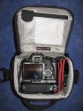 LOWEPRO - TOP LOADER ZOOM AW\n\nFoto von Peter Albrecht - VIELEN DANK!\n\nKommentar:\n\n- gekauft Januar 2009 (scheint auch berarbeitete Version zu sein gegenber dem Model, welches auch auf taschenfreak gezeigt wird)\n  neu: - Reisverschlu innen im Deckel hat jetzt eine Schutzkappe (Bild 06)\n       - SlipLock auf beiden Seiten (Bilder 02 und 04)\n\n- Beigaben:\n  - Schultergurt (Bild 05)\n  - Chest Harness (4 Kunststoffhaken) (Bild 05)\n      - Chest Harness, den man als extra Zubehr erwerben kann hat fr die oberen Ringe zwei Metallhaken\n      - Gurte lassen sich schnell und einfach verstellen\n      - keine Anleitung => erst mal experimentieren, aber man kriegs relativ schnell hin\n  - klitzekleine Anleitung fr die Tasche selbst (englisch / franzsisch / kein Deutsch)\n  - Werbeschild 30 Jahre Lowepro (ist dann wohl schon etwas lter) (Bild 01)\n\n- Innenraum mit 4 Trennern veriabel gestaltbar (Bilder 05, 07, 08 und 09)\n- beim 18-55mm Objektiv kann man problemlos das Ladegert fr die Akkus unter einem doppelten Boden verstauen (Bild 09)\n- die zwei groen Trenner haben noch seitliche Taschen fr Kleinzeugs (z.B. Akkus) (Bilder 05 und 08)\n- Zwei SlipLock Schlaufen (je eine links und rechts) (Bilder 02 und 04)\n- die oberen zwei Ringe zur Befestigung des Tragesystems sind aus Metall, die unteren aus Kunststoff, aber die sind ja nicht so wichtig.\n\n- Was geht rein?\n  - Canon 500D mit Batteriegriff und Tragegurt (Bild 06)\n  - Speedlite 430 EX II + Ersatzakkus + Zweitakku fr Camera (Bild 08)\n  - Ladegert (Bild 09)\n  - Zettel und Speicherkarte (Bild 10)\n  - Anleitungen fr Speedlite und 500D, Stifte, Taschenlampe (Bild 11)\n  - Mignon-Halter fr den Batteriegriff - aber UNGEPOLSTERT! (Bild 12)\n\n\n- All-Weather-Cover (AWC): (Bilder 13 - 16)\n  - Ringe und Gurtschlaufe fr Tragesysteme bleiben frei\n  - Deckel, Fronttasche, Seitentasche sind eingepackt (kein Zugang)\n  - SlipLock auch bei AWC verwendbar\n  - Tragsystem mu vor dem Aufziehen des AWC nicht entfernt werden\n  - Seite am Krper und die Hlfte der linken/rechten Seite (Sliplock) bleiben frei\n  - AWC ber langes Band fest mit Tasche vernht -> kein Verlieren\n\nNegativ:\n- Toploader-Deckel (geschwungen) pat zur Kamera-Form (eher flach) (Bild 17)\n- Blitznase spreitzt sich beim Einlegen an Klettverschlubasis (mit der Zeit lernt man aber, wie mans gut rein bringt)\n- Klettverschlu fr Innenraumteiler aufgenht -> sieht nicht so toll aus und man kann beim Einpacken daran hngen bleiben (EOS 500D) (Bilder 07 und 08)\n- Im Vergleich zum Toploader Pro 70 AW hat der Zoom AW eher ein Plastik-Feeling (besonders die Tasche im Deckel) (Bild 09)\n- Fronttasche garnicht gepolstert -> keine empfindlichen Sachen verstauen\n - im oberen Teil ist das AWC zwischen Tascheninhalt und auen (Bild 11)\n - unten gibts nur ein ungepolstertes Stck Stoff, den Mignon-Halter fr den Batteriegriff sollte man da NICHT transportiern (Bild 12)
