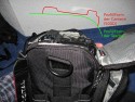 LOWEPRO - TOP LOADER ZOOM AW\n\nFoto von Peter Albrecht - VIELEN DANK!\n\nKommentar:\n\n- gekauft Januar 2009 (scheint auch berarbeitete Version zu sein gegenber dem Model, welches auch auf taschenfreak gezeigt wird)\n  neu: - Reisverschlu innen im Deckel hat jetzt eine Schutzkappe (Bild 06)\n       - SlipLock auf beiden Seiten (Bilder 02 und 04)\n\n- Beigaben:\n  - Schultergurt (Bild 05)\n  - Chest Harness (4 Kunststoffhaken) (Bild 05)\n      - Chest Harness, den man als extra Zubehr erwerben kann hat fr die oberen Ringe zwei Metallhaken\n      - Gurte lassen sich schnell und einfach verstellen\n      - keine Anleitung => erst mal experimentieren, aber man kriegs relativ schnell hin\n  - klitzekleine Anleitung fr die Tasche selbst (englisch / franzsisch / kein Deutsch)\n  - Werbeschild 30 Jahre Lowepro (ist dann wohl schon etwas lter) (Bild 01)\n\n- Innenraum mit 4 Trennern veriabel gestaltbar (Bilder 05, 07, 08 und 09)\n- beim 18-55mm Objektiv kann man problemlos das Ladegert fr die Akkus unter einem doppelten Boden verstauen (Bild 09)\n- die zwei groen Trenner haben noch seitliche Taschen fr Kleinzeugs (z.B. Akkus) (Bilder 05 und 08)\n- Zwei SlipLock Schlaufen (je eine links und rechts) (Bilder 02 und 04)\n- die oberen zwei Ringe zur Befestigung des Tragesystems sind aus Metall, die unteren aus Kunststoff, aber die sind ja nicht so wichtig.\n\n- Was geht rein?\n  - Canon 500D mit Batteriegriff und Tragegurt (Bild 06)\n  - Speedlite 430 EX II + Ersatzakkus + Zweitakku fr Camera (Bild 08)\n  - Ladegert (Bild 09)\n  - Zettel und Speicherkarte (Bild 10)\n  - Anleitungen fr Speedlite und 500D, Stifte, Taschenlampe (Bild 11)\n  - Mignon-Halter fr den Batteriegriff - aber UNGEPOLSTERT! (Bild 12)\n\n\n- All-Weather-Cover (AWC): (Bilder 13 - 16)\n  - Ringe und Gurtschlaufe fr Tragesysteme bleiben frei\n  - Deckel, Fronttasche, Seitentasche sind eingepackt (kein Zugang)\n  - SlipLock auch bei AWC verwendbar\n  - Tragsystem mu vor dem Aufziehen des AWC nicht entfernt werden\n  - Seite am Krper und die Hlfte der linken/rechten Seite (Sliplock) bleiben frei\n  - AWC ber langes Band fest mit Tasche vernht -> kein Verlieren\n\nNegativ:\n- Toploader-Deckel (geschwungen) pat zur Kamera-Form (eher flach) (Bild 17)\n- Blitznase spreitzt sich beim Einlegen an Klettverschlubasis (mit der Zeit lernt man aber, wie mans gut rein bringt)\n- Klettverschlu fr Innenraumteiler aufgenht -> sieht nicht so toll aus und man kann beim Einpacken daran hngen bleiben (EOS 500D) (Bilder 07 und 08)\n- Im Vergleich zum Toploader Pro 70 AW hat der Zoom AW eher ein Plastik-Feeling (besonders die Tasche im Deckel) (Bild 09)\n- Fronttasche garnicht gepolstert -> keine empfindlichen Sachen verstauen\n - im oberen Teil ist das AWC zwischen Tascheninhalt und auen (Bild 11)\n - unten gibts nur ein ungepolstertes Stck Stoff, den Mignon-Halter fr den Batteriegriff sollte man da NICHT transportiern (Bild 12)