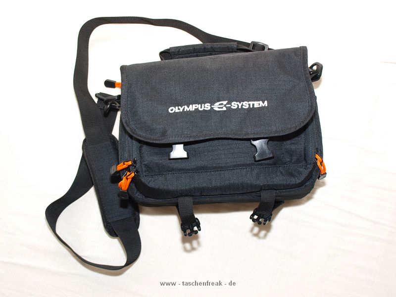 OLYMPUS E-SYSTEM SCHULTERTASCHE II\n\nFoto und Text von Thomas Rossmller - VIELEN DANK!\n\nKommentar:\n\nOlympus E-System Schultertasche II\n\nTrennwnde leider sehr dnn.\nBietet eher Platz fr 3 Objektive (1 auf Cam, 2 auf jeder Seite) als fr 2 Objektive + Blitz.\n\nEnthalten:\n2 L-frmige Trennwnde\n2 kleine Wnde\n1 groe Wand (oben)\n\nIn der Vordertasche und dem Deckel ist viel Platz fr kleines Zubehr (Filter, Putztcher, Lenspen, Fernbedienung).\n\nKompakte Tasche, in die verhltnismig (mit geschickter Anordnung) viel Zubehr geht. Trotzdem alles sehr knapp bemessen.