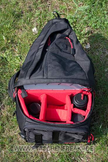 PENTAX X-BAG\n\nFoto und Kommentar von Olaf Mokansky - VIELEN DANK!\n\nKommentar:\n\nHallo Taschenfreak,\n\nleider ist dieser Rucksack in Deutschland kaum verfügbar/bekannt. Es \nhandelt sich um ein umgelabeltes Exemplar des Naneu Echo Pro mit \nfarblich auf Pentaxrot abgestimmtem Kamerateil und schwarzem \nAußenstoff.\n\nDas Material ist über jeden Zweifel erhaben, die Verarbeitung top und \ndas Ganze extrem leicht.\n\nDie Vordertaschen haben keinen Deckel da sollte also nichts \nfeuchtigkeitsempfindliches rein. Ansonsten sind die meisten \nReißverschlüsse (leider nicht der vom flachen Vorderfach) abgedeckt.\n\nDas Kamerafach kann man sich frei einteilen, es sind reichlich \nEinteilungen vorhanden, die beliebig angeordnet werden können. Und \nobwohl das Ganze nicht nur auf den Fotos recht klein aussieht sondern \nauch im Original, hatte ich keine Probleme, meine gesamte Ausrüstung \n(okay, fast die ganze) unterzubringen.\nPentax K-m mit 40er Limited, 12-24er Pentax, 18-55 Kit-Pentax, 55er \nNikkor mit Adapter und Zwischenringen, Lochblende und Polfilter, \nAkkus, Speicherkarten. Wahlweise lässt sich das Macro durch ein Tele \nersetzen, oder das 18-55 bleibt zuhause.\nIm oberen Teil ist Platz für eine Thermoskanne (1 Liter), Verpflegung, \nKartenmaterial, für längere Radtouren gibts ein extra iPod-Fach mit \nKopfhörerausgang.\n\nDie ersten Anproben versprechen einen guten rutschfesten Sitz