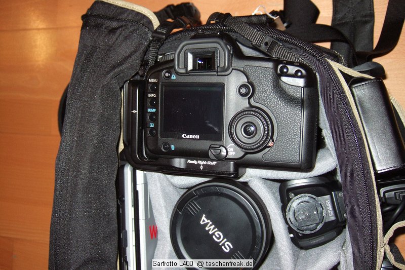 Sarfrotto L400\n\nFoto von Jörg Langer\n\nKommentar/Details:\n\nSehr hochwertige Profi-Fototasche\nvon Sarfrotto L 400 - All Weather kompatibel\n\nSuper Qualität zum günstigen Preis!\n- Sicherheit für Ihre Kamera, beste Polsterung!\n- Komplett variables, gepolstertes Innenfach\n- Schutz vor Regen, Staub, Schnee!\n- Regenhaube zum Überstülpen!\n- Schneller Zugriff zur Kamera durch einen Reiß-\nverschluss in der Mitte\n- Lasche zum Durchführen eines Waistbelts\n- Sehr Gut gepolsterter Gurt\n- Ideal für den Profieinsatz\n- Innenpolster herausnehmbar\n- Trennfächer können mit Klettverschluss ange-\nordnet werden\n\nBeschreibung\nDiese sehr leichten und hochwertigen Fototaschen sind sehr gut vearbeitet und bieten optimalen Schutz für Ihre Kameraasurüstung - und das bei praktischer und einfacher Handhabung.\n\nBesonders gelungen ist der weiche Gurt, er erlaubt bequemes Tragen der Fotoausrüstung. Der in der Mitte der Tasche liegende Reißverschluss ist super, für den schnellen Zugriff zur Kamera.\nDie Tasche bieten Schutz vor Regen, Staub, Schnee, etc.\n\nDie Tasche ist kompatibel mit den Waistbelts anderer Markenhersteller - die Weistbelts (Hüftgürtel) lassen sich ganz einfach durch die Lasche am hinteren Ende der Kamera ziehen.\n\nBei Bedarf kann das gepolsterte Innenfach herausgenommen werden. Die Tasche wird dadurch noch leichter und weicher.\n\nRegencover\n\nDetails der L 400:\n- Praktischer Tragegriff\n- Seitliche Laschen zum anschließen von Köchern, o.ä.\nMit Festzurrschlaufe zum fixieren der Köcher!\n- Geräumige Vordertasche für Ladegeräte, Speicher, Film,\nAkkus, etc. - eingeteilt in versch. Fächer.\n- Herausnehmbare Regenhaube für noch mehr Schutz\n- variable Fächer im gepolsterten Innenfach\n- 2x Innenliegendes „Geheimfach“ hinter der Polsterung\n- Gurtschlaufe hinten für Waistbelts\n- Bequemer, gepolsterter Gurt\n\nFassungsvermögen:\nSiehe Details auf den Bildern\n\nMaße\nInnen: ca. 32x17,5x25cm\nAußen: ca. 35x25x27,5cm