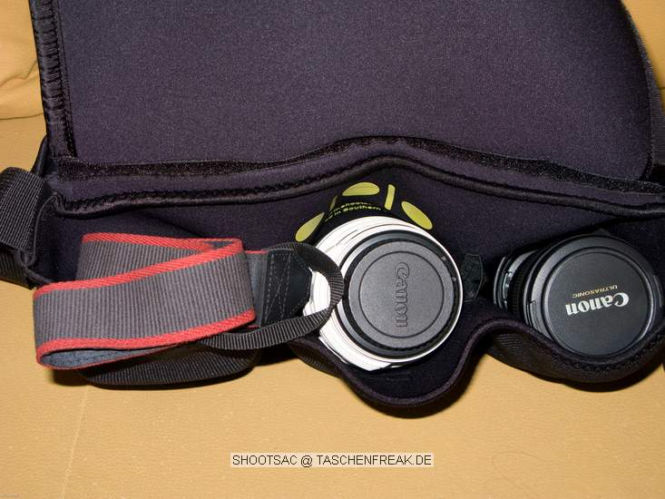 SHOOTSAC.COM\n\nFoto und Text von Jrg Langer - www.taschenfreak.de\n\nKommentar:\n\nDie Shootsac ist aus Neopren gefertigt und eine aus USA kommende Tasche die anders ist als andere Tasche. Man kann diese sehr angenehm am Krper tragen da die 3 bzw. 6 Kammern der Tasche einzelne Kammern sidn und sich dadurch schn anschmiegen. Der berwurf ist nur ein "bergeworfener" Deckel der keinen Verschluss oder Klett oder hnliches hat. Damit ist die Tasche prdestiniert fr Hochzeitsfotografen die in der Kirche die Linse wechseln wollen bzw. mssen und nicht gerade eine lauten Reissverschluss oder lrmenden Klettverschluss ffnen mchten um die ganze Zeremonie zu stren.\n\nWir haben die Shootsac getestet und finden Sie gut. \n\nMan kann darin aufgrund des Aufbaus der Kammern keine Camera mit angesetztem Objektiv transportieren. Das ist auch nicht der Sinn und Zweck der Tasche. Die Cam hat man im Arm oder umhngen und die zu wechselnden Linsen und Blitze in der Shootsac. Man kann gut 2 Speedlites und 3 Linsen verstauen.\n\nAlles in allem eine relativ einfach gemachte aber extravagante Tasche die viel Spa macht.\n\nZu kaufen nur in USA unter www.shootsac.com. Lieferung war bei uns innerhalb 3 Tage nach Bestellung via UPS da.\n\nNicht erschrecken - nicht ganz billig!\n\nAch ja, das Cover bzw. der berwurf ist auch in ganz vielen diversen Designs zu bestellen. Wir haben uns fr das klassiche Schwarz entschieden.\n\nVielleicht hilft es dem einen oder anderen.\n\nLG Jrg
