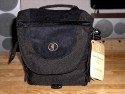 TAMRAC 3536 EXPRESS 6\n\nFoto und Text von Jonas - VIELEN DANK!\n\nKommentar:\n\nTamrac Express 6 mini-Review von Jonas\n\nDiese Tasche sieht vor allem gut aus und ist gut verarbeitet - aber sie ist klein!\nMehr als eine Kamera ohne Batteriegriff, ein 2. Objektiv und einen Blitz bekommt man nicht unter. Auerdem sitzt alles sehr eng aneinander und man muss das 2. Objektiv immer ziemlich "reinwrgen". Und das schreibe ich als Olympus E-620 Nutzer, ich will mir gar nicht ausdenken, was Canons bildstabilisierte Objektive an Platz bentigen. Dazu kommt, dass die Klettstreifen an festen Positionen sitzen und die Trenner nicht wie z.B. bei Crumpler berall am Innenfutter festgeklettet werden knnen. Die Klettstreifen sind auch noch recht hart, was zu Kratzern auf der Kamera fhren knnte (habe die Tasche noch nicht lange genug im Einsatz). Dabei sind zwei groe Trenner und zwei kleine, die zur horizontalen Unterteilung eingesetzt werden knnen. Die groen Trenner sind mir etwas zu lang, so dass die Kamera zu hoch sitzt (direkt an der Kante). Habe sie tiefer eingesetzt, was jedoch mit dem Klett nicht so gut passt.\n\nBei mir sind in der Tasche:\n- Olympus E-620 mit 14-42mm Objektiv + Sonnenblende (kann auch richtig herum drauf sein, die Tasche ist tief genug. Alternativ wrde vermutlich noch ein 25mm Pancake unten drunter passen.\n- Ein 40-150mm Objektiv mit Sonnenblende verkehrt herum aufgesetzt.\n- Das Ladegert\nDazu in der Fronttasche:\n- Anleitung\n- Kabel\n- Objektivdeckel des aufgesetzten Objektivs\nIn die Deckeltasche sowie in die Tasche hinten passt eigentlich nur ein Blatt Papier. Bisher sind sie leer geblieben. Hatte gehofft, die Anleitung hinten rein stecken zu knnen. Die Seitentasche passt wohl fr ein Handy oder MP3-Player, bisher ist sie leergeblieben.\n\nIch wrde beim nchsten Mal eine Nummer grer kaufen (Express 7). Vom Design wie von der Verarbeitung her passt alles.