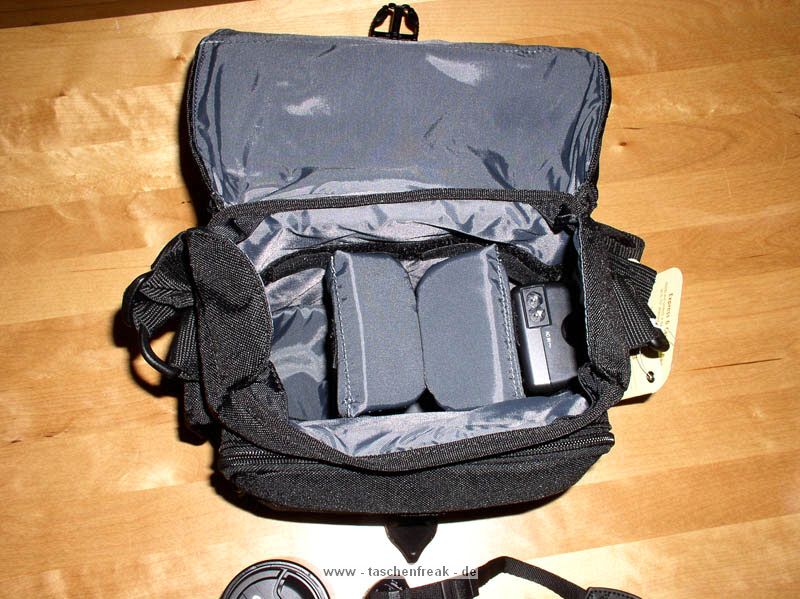 TAMRAC 3536 EXPRESS 6\n\nFoto und Text von Jonas - VIELEN DANK!\n\nKommentar:\n\nTamrac Express 6 mini-Review von Jonas\n\nDiese Tasche sieht vor allem gut aus und ist gut verarbeitet - aber sie ist klein!\nMehr als eine Kamera ohne Batteriegriff, ein 2. Objektiv und einen Blitz bekommt man nicht unter. Auerdem sitzt alles sehr eng aneinander und man muss das 2. Objektiv immer ziemlich "reinwrgen". Und das schreibe ich als Olympus E-620 Nutzer, ich will mir gar nicht ausdenken, was Canons bildstabilisierte Objektive an Platz bentigen. Dazu kommt, dass die Klettstreifen an festen Positionen sitzen und die Trenner nicht wie z.B. bei Crumpler berall am Innenfutter festgeklettet werden knnen. Die Klettstreifen sind auch noch recht hart, was zu Kratzern auf der Kamera fhren knnte (habe die Tasche noch nicht lange genug im Einsatz). Dabei sind zwei groe Trenner und zwei kleine, die zur horizontalen Unterteilung eingesetzt werden knnen. Die groen Trenner sind mir etwas zu lang, so dass die Kamera zu hoch sitzt (direkt an der Kante). Habe sie tiefer eingesetzt, was jedoch mit dem Klett nicht so gut passt.\n\nBei mir sind in der Tasche:\n- Olympus E-620 mit 14-42mm Objektiv + Sonnenblende (kann auch richtig herum drauf sein, die Tasche ist tief genug. Alternativ wrde vermutlich noch ein 25mm Pancake unten drunter passen.\n- Ein 40-150mm Objektiv mit Sonnenblende verkehrt herum aufgesetzt.\n- Das Ladegert\nDazu in der Fronttasche:\n- Anleitung\n- Kabel\n- Objektivdeckel des aufgesetzten Objektivs\nIn die Deckeltasche sowie in die Tasche hinten passt eigentlich nur ein Blatt Papier. Bisher sind sie leer geblieben. Hatte gehofft, die Anleitung hinten rein stecken zu knnen. Die Seitentasche passt wohl fr ein Handy oder MP3-Player, bisher ist sie leergeblieben.\n\nIch wrde beim nchsten Mal eine Nummer grer kaufen (Express 7). Vom Design wie von der Verarbeitung her passt alles.