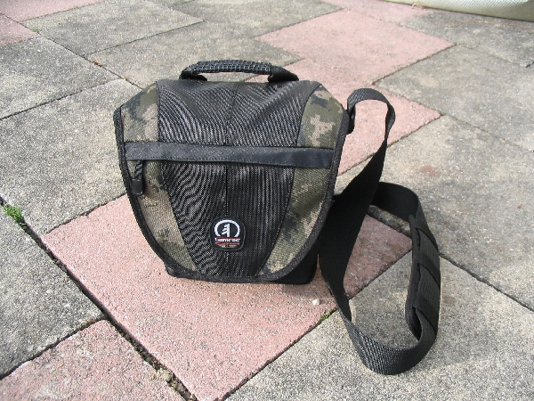 TAMRAC 5533- ADVENTURE MESSENGER 3\n\nFoto von Udo Boesch - Vielen Dank!\n\nKommentar des Nutzers:\n\nHallo J�rg Langer,\n \nich habe ein paar Bilder von einer Tamrac Adventure Messenger 3 Tasche. Es w�rde mich sehr freuen, wenn du sie bei dir in deiner Page aufnehmen w�rdest.\n \nHier ein paar Infos dazu:\n \nDie Tamrac-Adventure-Messenger-3 Fototasche bietet laut Hersteller Platz f�r eine Spiegelreflex mit aufgesetztem Objektiv bis zu 12,5cm L�nge. Ich besitze eine Bridgekamera Fuji S9600, diese passt wirklich prima hinein. Das Hauptfach selbst ist mit 2 verstellbaren, schaumstoffgepolsterten Unterteilungen ausgestattet. Diese k�nnen mit Klettverschl�ssen individuell angepasst werden, so passt wirklich jede Kamera, egal wie breit in die Tasche. Selbstverst�ndlich k�nnen auch links und rechts Zusatzblitz oder zus�tzliche Objektive verstaut werden. Die Tasche bietet den Vorteil, dass hier kleine mit Klettverschluss best�ckten schaumstoffgepolsterten Zwischenb�den eingebracht werden k�nnen. So liegt das Objektiv gesch�tzt auf diesem Zwischenteil auf.\n \nDie Vortasche wird mit Reissverschl�ssen gesichert und beinhaltet 2 Einsteckf�cher. Im Deckel befindet sich ein reissverschlussgesichertes flaches Einsteckfach.\nSeitlich (li + re) sind aufgesetzte Taschen, einmal mit Klettverschluss f�r Handy o.�, auf der anderen Seite ohne Klettverschluss.\nAn der R�ckwand ist ebenfalls eine aufgesetzte Tasche mit Reissverschluss, ideal f�r eine Bedienungsanleitung o.�.\nDer Umh�ngegurt ist sch�n breit und mit einem rutschsicherem Schulterpolster versehen. Desweiteren hat die Tasche einen EasyGrip Tragegriff. \n \nDie Ma�e der Tasche lt. Hersteller:\nAu�enma�e: 23 x 23 x 14 cm (BxHxT)\nInnenma�e: 20 x 20 x 10 cm (BxHxT) \nGewicht: 630 g\n \nHinweis: Alle Reissverschl�sse sind regengesch�tzt.\n \nFolgen Farben sind m�glich: Camouflage, rot/schwarz und grau/schwarz.\n \nPreis: 39,90 �\n \n \nInfos zu den einzelnen Bildern.\n \nBild 1: Frontansicht der Tasche (Camouflage) mit Tragegurt\nBild 2: R�ckansicht der Tasche mit Reissverschlussfach f�r Bedienungsanleiung\nBild 3: Seitenansicht mit Handyfach\nBild 4: Innenfach mit Kamera darin\nBild 5: Vortasche mit den zwei Einsteckf�chern.\nBild 6: Vortasche mit den zwei Einsteckf�chern\nBild 7: Hauptfach mit den zwei verstellbaren, schaumstoffgepolsterten Unterteilungen\nBild 8: Unterteilungen mit Klettverschluss verstell- und individuell anpassbar.\nBild 9: Hauptfach mit Kamera darin.\nBild 10: Tasche Frontansicht mit Verschluss\nBild 11: Gepolsterter rutschsicherer Tragegurt mit Polster (Innenseite)\nBild12: Gepolsterter rutschsicherer Tragegurt mit Polster (Aussenseite)