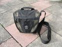 TAMRAC 5533- ADVENTURE MESSENGER 3\n\nFoto von Udo Boesch - Vielen Dank!\n\nKommentar des Nutzers:\n\nHallo Jrg Langer,\n \nich habe ein paar Bilder von einer Tamrac Adventure Messenger 3 Tasche. Es wrde mich sehr freuen, wenn du sie bei dir in deiner Page aufnehmen wrdest.\n \nHier ein paar Infos dazu:\n \nDie Tamrac-Adventure-Messenger-3 Fototasche bietet laut Hersteller Platz fr eine Spiegelreflex mit aufgesetztem Objektiv bis zu 12,5cm Lnge. Ich besitze eine Bridgekamera Fuji S9600, diese passt wirklich prima hinein. Das Hauptfach selbst ist mit 2 verstellbaren, schaumstoffgepolsterten Unterteilungen ausgestattet. Diese knnen mit Klettverschlssen individuell angepasst werden, so passt wirklich jede Kamera, egal wie breit in die Tasche. Selbstverstndlich knnen auch links und rechts Zusatzblitz oder zustzliche Objektive verstaut werden. Die Tasche bietet den Vorteil, dass hier kleine mit Klettverschluss bestckten schaumstoffgepolsterten Zwischenbden eingebracht werden knnen. So liegt das Objektiv geschtzt auf diesem Zwischenteil auf.\n \nDie Vortasche wird mit Reissverschlssen gesichert und beinhaltet 2 Einsteckfcher. Im Deckel befindet sich ein reissverschlussgesichertes flaches Einsteckfach.\nSeitlich (li + re) sind aufgesetzte Taschen, einmal mit Klettverschluss fr Handy o., auf der anderen Seite ohne Klettverschluss.\nAn der Rckwand ist ebenfalls eine aufgesetzte Tasche mit Reissverschluss, ideal fr eine Bedienungsanleitung o..\nDer Umhngegurt ist schn breit und mit einem rutschsicherem Schulterpolster versehen. Desweiteren hat die Tasche einen EasyGrip Tragegriff. \n \nDie Mae der Tasche lt. Hersteller:\nAuenmae: 23 x 23 x 14 cm (BxHxT)\nInnenmae: 20 x 20 x 10 cm (BxHxT) \nGewicht: 630 g\n \nHinweis: Alle Reissverschlsse sind regengeschtzt.\n \nFolgen Farben sind mglich: Camouflage, rot/schwarz und grau/schwarz.\n \nPreis: 39,90 \n \n \nInfos zu den einzelnen Bildern.\n \nBild 1: Frontansicht der Tasche (Camouflage) mit Tragegurt\nBild 2: Rckansicht der Tasche mit Reissverschlussfach fr Bedienungsanleiung\nBild 3: Seitenansicht mit Handyfach\nBild 4: Innenfach mit Kamera darin\nBild 5: Vortasche mit den zwei Einsteckfchern.\nBild 6: Vortasche mit den zwei Einsteckfchern\nBild 7: Hauptfach mit den zwei verstellbaren, schaumstoffgepolsterten Unterteilungen\nBild 8: Unterteilungen mit Klettverschluss verstell- und individuell anpassbar.\nBild 9: Hauptfach mit Kamera darin.\nBild 10: Tasche Frontansicht mit Verschluss\nBild 11: Gepolsterter rutschsicherer Tragegurt mit Polster (Innenseite)\nBild12: Gepolsterter rutschsicherer Tragegurt mit Polster (Aussenseite)