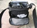 TAMRAC 5533- ADVENTURE MESSENGER 3\n\nFoto von Udo Boesch - Vielen Dank!\n\nKommentar des Nutzers:\n\nHallo Jrg Langer,\n \nich habe ein paar Bilder von einer Tamrac Adventure Messenger 3 Tasche. Es wrde mich sehr freuen, wenn du sie bei dir in deiner Page aufnehmen wrdest.\n \nHier ein paar Infos dazu:\n \nDie Tamrac-Adventure-Messenger-3 Fototasche bietet laut Hersteller Platz fr eine Spiegelreflex mit aufgesetztem Objektiv bis zu 12,5cm Lnge. Ich besitze eine Bridgekamera Fuji S9600, diese passt wirklich prima hinein. Das Hauptfach selbst ist mit 2 verstellbaren, schaumstoffgepolsterten Unterteilungen ausgestattet. Diese knnen mit Klettverschlssen individuell angepasst werden, so passt wirklich jede Kamera, egal wie breit in die Tasche. Selbstverstndlich knnen auch links und rechts Zusatzblitz oder zustzliche Objektive verstaut werden. Die Tasche bietet den Vorteil, dass hier kleine mit Klettverschluss bestckten schaumstoffgepolsterten Zwischenbden eingebracht werden knnen. So liegt das Objektiv geschtzt auf diesem Zwischenteil auf.\n \nDie Vortasche wird mit Reissverschlssen gesichert und beinhaltet 2 Einsteckfcher. Im Deckel befindet sich ein reissverschlussgesichertes flaches Einsteckfach.\nSeitlich (li + re) sind aufgesetzte Taschen, einmal mit Klettverschluss fr Handy o., auf der anderen Seite ohne Klettverschluss.\nAn der Rckwand ist ebenfalls eine aufgesetzte Tasche mit Reissverschluss, ideal fr eine Bedienungsanleitung o..\nDer Umhngegurt ist schn breit und mit einem rutschsicherem Schulterpolster versehen. Desweiteren hat die Tasche einen EasyGrip Tragegriff. \n \nDie Mae der Tasche lt. Hersteller:\nAuenmae: 23 x 23 x 14 cm (BxHxT)\nInnenmae: 20 x 20 x 10 cm (BxHxT) \nGewicht: 630 g\n \nHinweis: Alle Reissverschlsse sind regengeschtzt.\n \nFolgen Farben sind mglich: Camouflage, rot/schwarz und grau/schwarz.\n \nPreis: 39,90 \n \n \nInfos zu den einzelnen Bildern.\n \nBild 1: Frontansicht der Tasche (Camouflage) mit Tragegurt\nBild 2: Rckansicht der Tasche mit Reissverschlussfach fr Bedienungsanleiung\nBild 3: Seitenansicht mit Handyfach\nBild 4: Innenfach mit Kamera darin\nBild 5: Vortasche mit den zwei Einsteckfchern.\nBild 6: Vortasche mit den zwei Einsteckfchern\nBild 7: Hauptfach mit den zwei verstellbaren, schaumstoffgepolsterten Unterteilungen\nBild 8: Unterteilungen mit Klettverschluss verstell- und individuell anpassbar.\nBild 9: Hauptfach mit Kamera darin.\nBild 10: Tasche Frontansicht mit Verschluss\nBild 11: Gepolsterter rutschsicherer Tragegurt mit Polster (Innenseite)\nBild12: Gepolsterter rutschsicherer Tragegurt mit Polster (Aussenseite)
