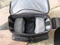 TAMRAC 5533- ADVENTURE MESSENGER 3\n\nFoto von Udo Boesch - Vielen Dank!\n\nKommentar des Nutzers:\n\nHallo Jrg Langer,\n \nich habe ein paar Bilder von einer Tamrac Adventure Messenger 3 Tasche. Es wrde mich sehr freuen, wenn du sie bei dir in deiner Page aufnehmen wrdest.\n \nHier ein paar Infos dazu:\n \nDie Tamrac-Adventure-Messenger-3 Fototasche bietet laut Hersteller Platz fr eine Spiegelreflex mit aufgesetztem Objektiv bis zu 12,5cm Lnge. Ich besitze eine Bridgekamera Fuji S9600, diese passt wirklich prima hinein. Das Hauptfach selbst ist mit 2 verstellbaren, schaumstoffgepolsterten Unterteilungen ausgestattet. Diese knnen mit Klettverschlssen individuell angepasst werden, so passt wirklich jede Kamera, egal wie breit in die Tasche. Selbstverstndlich knnen auch links und rechts Zusatzblitz oder zustzliche Objektive verstaut werden. Die Tasche bietet den Vorteil, dass hier kleine mit Klettverschluss bestckten schaumstoffgepolsterten Zwischenbden eingebracht werden knnen. So liegt das Objektiv geschtzt auf diesem Zwischenteil auf.\n \nDie Vortasche wird mit Reissverschlssen gesichert und beinhaltet 2 Einsteckfcher. Im Deckel befindet sich ein reissverschlussgesichertes flaches Einsteckfach.\nSeitlich (li + re) sind aufgesetzte Taschen, einmal mit Klettverschluss fr Handy o., auf der anderen Seite ohne Klettverschluss.\nAn der Rckwand ist ebenfalls eine aufgesetzte Tasche mit Reissverschluss, ideal fr eine Bedienungsanleitung o..\nDer Umhngegurt ist schn breit und mit einem rutschsicherem Schulterpolster versehen. Desweiteren hat die Tasche einen EasyGrip Tragegriff. \n \nDie Mae der Tasche lt. Hersteller:\nAuenmae: 23 x 23 x 14 cm (BxHxT)\nInnenmae: 20 x 20 x 10 cm (BxHxT) \nGewicht: 630 g\n \nHinweis: Alle Reissverschlsse sind regengeschtzt.\n \nFolgen Farben sind mglich: Camouflage, rot/schwarz und grau/schwarz.\n \nPreis: 39,90 \n \n \nInfos zu den einzelnen Bildern.\n \nBild 1: Frontansicht der Tasche (Camouflage) mit Tragegurt\nBild 2: Rckansicht der Tasche mit Reissverschlussfach fr Bedienungsanleiung\nBild 3: Seitenansicht mit Handyfach\nBild 4: Innenfach mit Kamera darin\nBild 5: Vortasche mit den zwei Einsteckfchern.\nBild 6: Vortasche mit den zwei Einsteckfchern\nBild 7: Hauptfach mit den zwei verstellbaren, schaumstoffgepolsterten Unterteilungen\nBild 8: Unterteilungen mit Klettverschluss verstell- und individuell anpassbar.\nBild 9: Hauptfach mit Kamera darin.\nBild 10: Tasche Frontansicht mit Verschluss\nBild 11: Gepolsterter rutschsicherer Tragegurt mit Polster (Innenseite)\nBild12: Gepolsterter rutschsicherer Tragegurt mit Polster (Aussenseite)