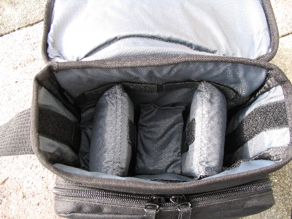 TAMRAC 5533- ADVENTURE MESSENGER 3\n\nFoto von Udo Boesch - Vielen Dank!\n\nKommentar des Nutzers:\n\nHallo Jrg Langer,\n \nich habe ein paar Bilder von einer Tamrac Adventure Messenger 3 Tasche. Es wrde mich sehr freuen, wenn du sie bei dir in deiner Page aufnehmen wrdest.\n \nHier ein paar Infos dazu:\n \nDie Tamrac-Adventure-Messenger-3 Fototasche bietet laut Hersteller Platz fr eine Spiegelreflex mit aufgesetztem Objektiv bis zu 12,5cm Lnge. Ich besitze eine Bridgekamera Fuji S9600, diese passt wirklich prima hinein. Das Hauptfach selbst ist mit 2 verstellbaren, schaumstoffgepolsterten Unterteilungen ausgestattet. Diese knnen mit Klettverschlssen individuell angepasst werden, so passt wirklich jede Kamera, egal wie breit in die Tasche. Selbstverstndlich knnen auch links und rechts Zusatzblitz oder zustzliche Objektive verstaut werden. Die Tasche bietet den Vorteil, dass hier kleine mit Klettverschluss bestckten schaumstoffgepolsterten Zwischenbden eingebracht werden knnen. So liegt das Objektiv geschtzt auf diesem Zwischenteil auf.\n \nDie Vortasche wird mit Reissverschlssen gesichert und beinhaltet 2 Einsteckfcher. Im Deckel befindet sich ein reissverschlussgesichertes flaches Einsteckfach.\nSeitlich (li + re) sind aufgesetzte Taschen, einmal mit Klettverschluss fr Handy o., auf der anderen Seite ohne Klettverschluss.\nAn der Rckwand ist ebenfalls eine aufgesetzte Tasche mit Reissverschluss, ideal fr eine Bedienungsanleitung o..\nDer Umhngegurt ist schn breit und mit einem rutschsicherem Schulterpolster versehen. Desweiteren hat die Tasche einen EasyGrip Tragegriff. \n \nDie Mae der Tasche lt. Hersteller:\nAuenmae: 23 x 23 x 14 cm (BxHxT)\nInnenmae: 20 x 20 x 10 cm (BxHxT) \nGewicht: 630 g\n \nHinweis: Alle Reissverschlsse sind regengeschtzt.\n \nFolgen Farben sind mglich: Camouflage, rot/schwarz und grau/schwarz.\n \nPreis: 39,90 \n \n \nInfos zu den einzelnen Bildern.\n \nBild 1: Frontansicht der Tasche (Camouflage) mit Tragegurt\nBild 2: Rckansicht der Tasche mit Reissverschlussfach fr Bedienungsanleiung\nBild 3: Seitenansicht mit Handyfach\nBild 4: Innenfach mit Kamera darin\nBild 5: Vortasche mit den zwei Einsteckfchern.\nBild 6: Vortasche mit den zwei Einsteckfchern\nBild 7: Hauptfach mit den zwei verstellbaren, schaumstoffgepolsterten Unterteilungen\nBild 8: Unterteilungen mit Klettverschluss verstell- und individuell anpassbar.\nBild 9: Hauptfach mit Kamera darin.\nBild 10: Tasche Frontansicht mit Verschluss\nBild 11: Gepolsterter rutschsicherer Tragegurt mit Polster (Innenseite)\nBild12: Gepolsterter rutschsicherer Tragegurt mit Polster (Aussenseite)