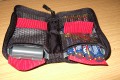 Foto von Jrg Langer\n\nKommentar des Nutzers:\n\nDieses kleine Batterypack fasst entweder 5 Akkus fr kleine DSLRs oder 16 AA Zellen fr den Blitz.\n\nWir haben hier 3x Akku fr die Canon 350D und 8x AA Zellen fr den Blitz. \n\nEbenfalls knnen hier auch Speichercards verstaut werden.\n\nIdeal, klein, gnstig und durch die Druckknopfgesicherte Schlaufe auch am Grtel zu befestigen.
