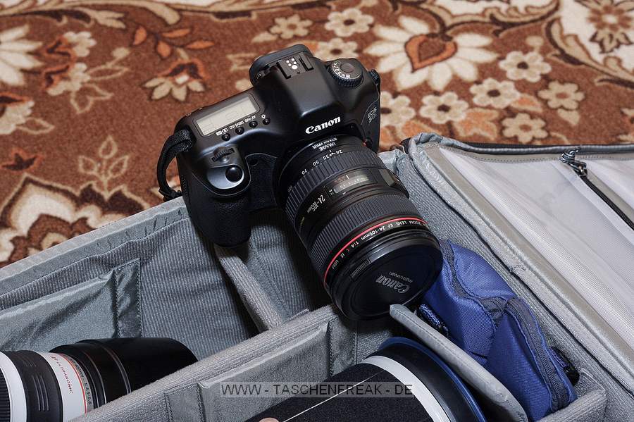 THINK TANK PHOTO - AIRPORT ADDICTED V 2\n\nKommentar und Fotos von einem befreundeten Fotografen der namentlich ungenannt bleibt.\n\nKommentar:\n\nDer Rucksack entspricht in allem einem etwas größeren Airport Acceleration V2. Die Vortasche, Notebook-tasche, Tragevorrichtung, etc. kann man sich daher auf diesen Bildern anschauen. Mit dabei sind eine Stativhalterung sowie ein Regenschutz.\n\nFür den Einsatz habe ich den Rucksack so eingeteilt, dass rechts/mitte ein 1er Gehäuse mit angesetztem 4/400 DO und richtig aufgesetzter GeLi reinpasst, auch mit Konverter. Der restliche Platz davor wird mit Batteriepacks für die 1er belegt. An der linken Seite ist eine 40er mit angesetztem 100-400 sowie richtig aufgesetzter GeLi. Der Platz davor wird mit einer 5er und angesetztem 24-105 (ohne GeLi) belegt, die mit dem Objektiv nach unten noch grade so in den Rucksack passt.\n\nDie freien Plätze an der rechten Seite sind mit Konverter, Zwischenringen, 16-35er (ohne GeLi) und 150er Sigma Makro (ohne GeLi und ohne Stativschelle) belegt, ein Blitz hat auch noch Platz.\n\nFür den Tranport sind die langen Teles nicht am Gehäuse montiert. Wenn man dann noch die GeLi`s vom 400er und 100-400 umgekehrt aufsteckt, ergibt sich im Rucksack weiterer Platz für z.b. ein Fernglas, sowie weiteres Zubehör.