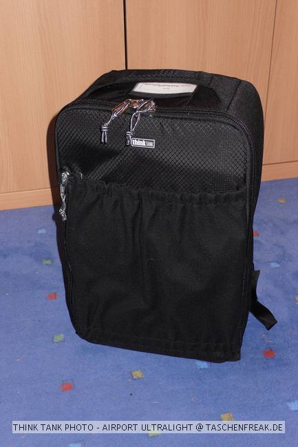 THINK TANK PHOTO - AIRPORT ULTRALIGHT\n\nFoto von Jörg Langer - www.taschenfreak.de\n\nKommentar des Nutzers:\n\nDer Airport Ultralight, ist der kleinste Rucksack der Airport Serie von Think Tank Photo. Dennoch ist auch er ein kleines Packwunder. Von den Außenmaßen ist er mit einem Lowepro Mini Trecker durchaus vergleichbar (ggf. etwas höher).\n\nEs passen in unserem Beispiel bequem hinein:\n5D mit 24-70 2,8 mit Geli richtig aufgesetzt\n30D mit 100-400L IS\n70-200 4.0 mit Stativschelle\n17-40\n50 1,4\n100 2,8\nTelekonverter\n580er Blitz\nSpeicherkarten Etui\nkl. Akku Tasche für 3x BP511\nkl. Akku Tasche für 8x AA Zellen für Blitz\nPanoschiene von RRS\nRRS L-Winkel an beiden Bodys\nTimer Fernbedienung\nund vorne in das Frontfach ganz bequem unser 12" Notebook/Tablet PC im Sleeve.\n\nDas Gewicht ist super bequem (deutlich bequemer als beim Mini oder Compu Trekker) auf den Schultern verteilt, obwohl die Schultergurte so leicht und schwach wirken auf den ersten Blick. Da steckt gekonnte Think Tank Entwicklung dahinter.\n\nGeliefert wird der Ultralight mit abhehmbaren Beckengurt und einem Regencover das auch auf einigen Bildern zu sehen ist.\n\nEinziges für uns erkennbares Manko ist das dieser Think Tank Rucksack keine Stativhalterung hat (die wir eh nicht nutzen, aber viele - warum auch immer - diese gerne nutzen möchten). Wir tragen unser Stativ an einem langen Umhängegurt wie eine Flinte unter dem Arm und der Umhängegurt ist auch bequem in Verbindung mit einem Rucksack zu nutzen.\n\nWer seinen Ultralight besonders schützen möchte kann diesen gerade so passend (etwas drücken muss man aber ..) in einem PeliCase 1510 Trolly Koffer reinpacken und damit hinter sich herziehen. Ein Notebook darf dann aber nicht in der Frontasche des Notebooks legenund zu eng sollte es im Rucksack auch nicht "zugehen", damit man das Peli Case noch anständig und wasserdicht verschließen kann.\n\nEr ist jeden Cent den er teurer als ein vergleichbarer Rucksack anderer Hersteller ist wert, aber das kann man nicht auf Fotos "rüberbringen", aber dieses werden Ihnen viele zufriedenen Think Tank Kunden bestätigen.\n\nWie immer bei den Think Tank Produkten bekommt auch dieser unser Prädikat "BESONDERS EMPFEHLENSWERT".