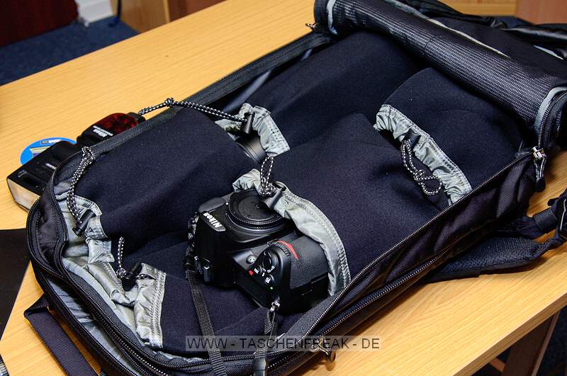 THINK TANK PHOTO - SHAPE SHIFTER\n\nFoto und Kommentar von Jrg Langer - www.taschenfreak.de\n\nKommentar:\n\nDer Shape Shifter, den wir freundlicherweise von ISARFOTO fr einen Bericht und Test fr Euch liebe Pagebesucher, zur Verfgung gestellt bekommen haben, lst bei uns den WOW Effekt aus.\n\nSehr schmal bzw. flach liegt er da auf dem Tisch und man fragt sich wie man das ganze Zeugs da rein bekommen soll ...\n\nLaut Hersteller sind 17" Notebook plus dessen Zubehr, 2x Profibodys, 3x 2.8er Profilinsen und jede Menge Zubehr kein Problem fr dieses Teil.\n\nRECHT HAT ER DER HERSTELLER! Null Problem das alles darin zu verstauen und dennoch wirklich sehr bequem auf dem Rcken zu tragen.\n\nWas haben wir mal eben darin verstaut:\n\nBody D3\nBody D300 mit BG\n17-35 2.8\n24-70 2.8\n70-200 2.8\n85 1.4\nSB-900\nMBP 17" Unibody (wenn es eins gbe wrde auch ein 19" passen ...)\nNetzteil MBP, Maus, u.v.m.\n\nDie im Hauptfach beindlichen Neopren einzelhllen sind grandios, sehr flexibel und dennoch hochschtzend fr das Equipment. Wir hatten vor einigen Monaten auch mal den Stealth Reporter II vom anderen groen Taschenhersteller - glaubt uns bitte - es liegen WELTEN dazwischen in der Verarbeitung des inneren und ueren dieses Shape Shifters!\n\nWenn man das Fotofach nicht nutzt kann man den Rucksack als reinen Notebookrucksack mit einem umlaufenden Reissverschluss smarter und flacher machen - ein sicher sehr ntzliches Detail wenn man Abends das ganze Fotozeugs im Hotel lsst und die Agentur oder die Kollegen mit dem Notebook aufsucht. \n\nJede Menge Kleinkram und persnliches was man so braucht und auch noch 2 weitere Blitze wren kein Problem - und das faszinierende: ES TUT NICHT WEH auf dem Rcken - der Shape Shifter bleibt sehr bequem und durch seinen eigentlich weichen Aufbau ist er sehr angenehm und nirgends strend auf dem Rcken - also auch whrend dem "Paparazzen" kann man diesen Rucksack aufbehalten.\n\nFazit: Wer Reportageartig fotografiert findet hier sein Werkzeug - ganz sicher!
