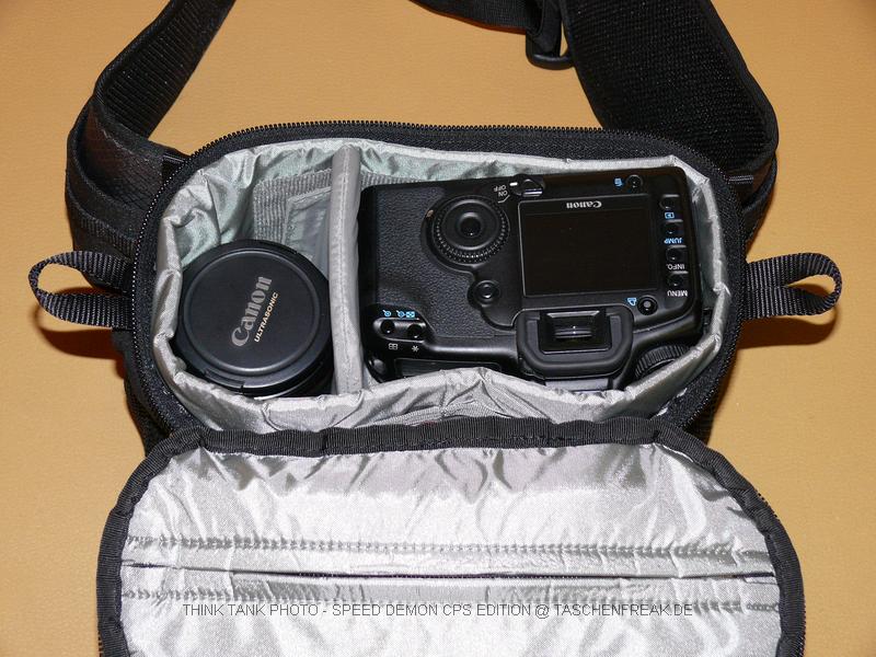 THINK TANK PHOTO - SPEED DEMON CPS EDITION\n\nFoto von Jrg Langer\n\nKommentar des Nutzers:\n\nDie Speed Demon ist m.W. die kleinste Think Tank Hfttasche. Hier passt bequem eine DSLR ohne Batteriegriff mit angesetztem Objektiv (in unserem Fall ein 35 1,4) hinein und ein weiteres Objektiv nebendran (in unserem Falle ein 135 2.0). Des weiteren kann ich zustzlich ein kleines Blitzgert verstauen (in unserem Falle ein Canon 220EX).\n\nEinen Regenschutz gibt es zudem. Die Fronttasche ist recht gerumig und beherbergt bequem ein Speichercard-Case, Ersatzakkus und ein Handy oder Ipod.\n\nDer Hftgurt ist im Vergleich zu den von Lowepro und Co hier sehr weit und auch fr XXL Menschen geeignet.\n\nDer Deckel wird vom Krper weg geffnet und dadurch nicht im Weg beim Zugriff auf den Tascheninhalt.